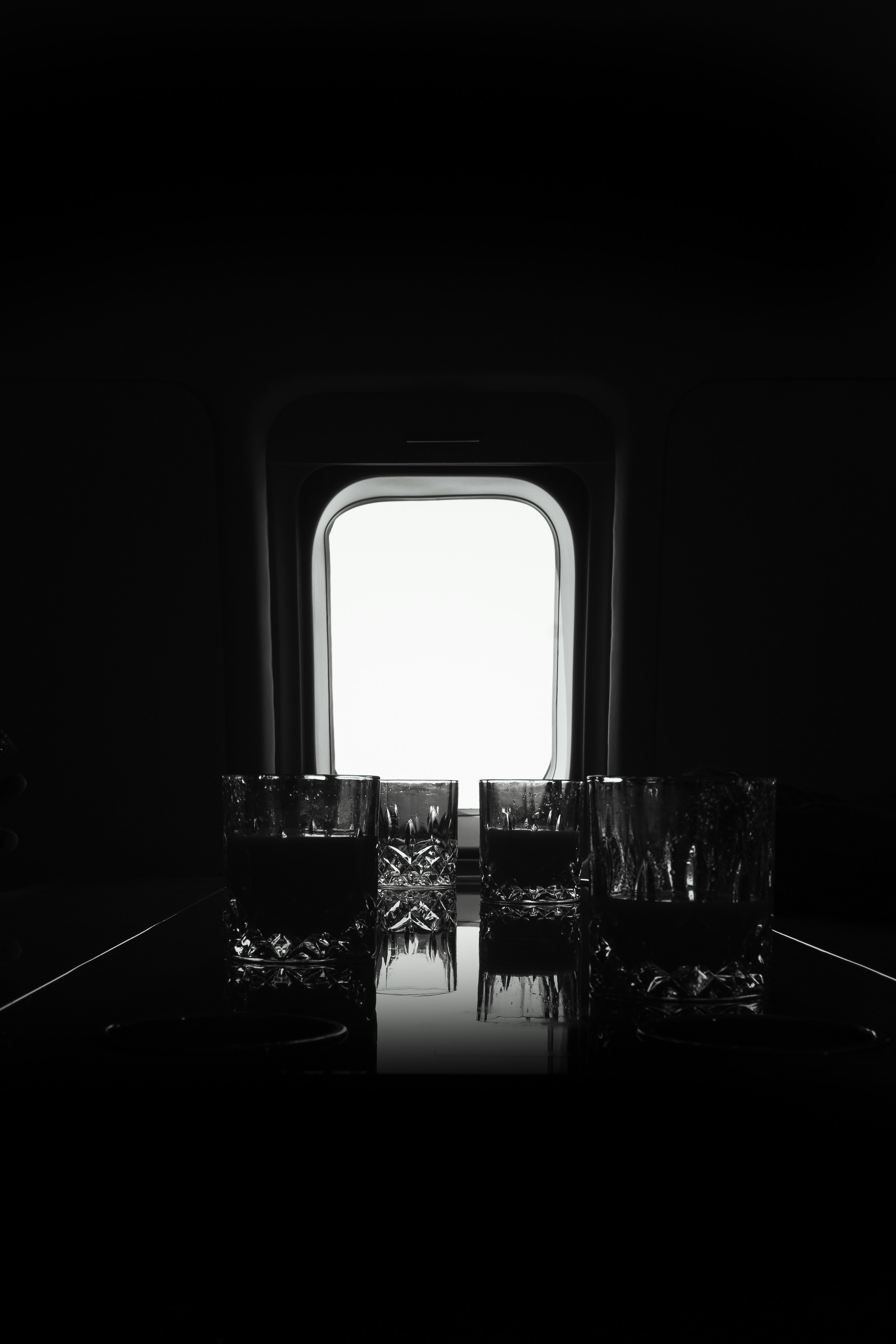 A black and white photo of a window in a dark room