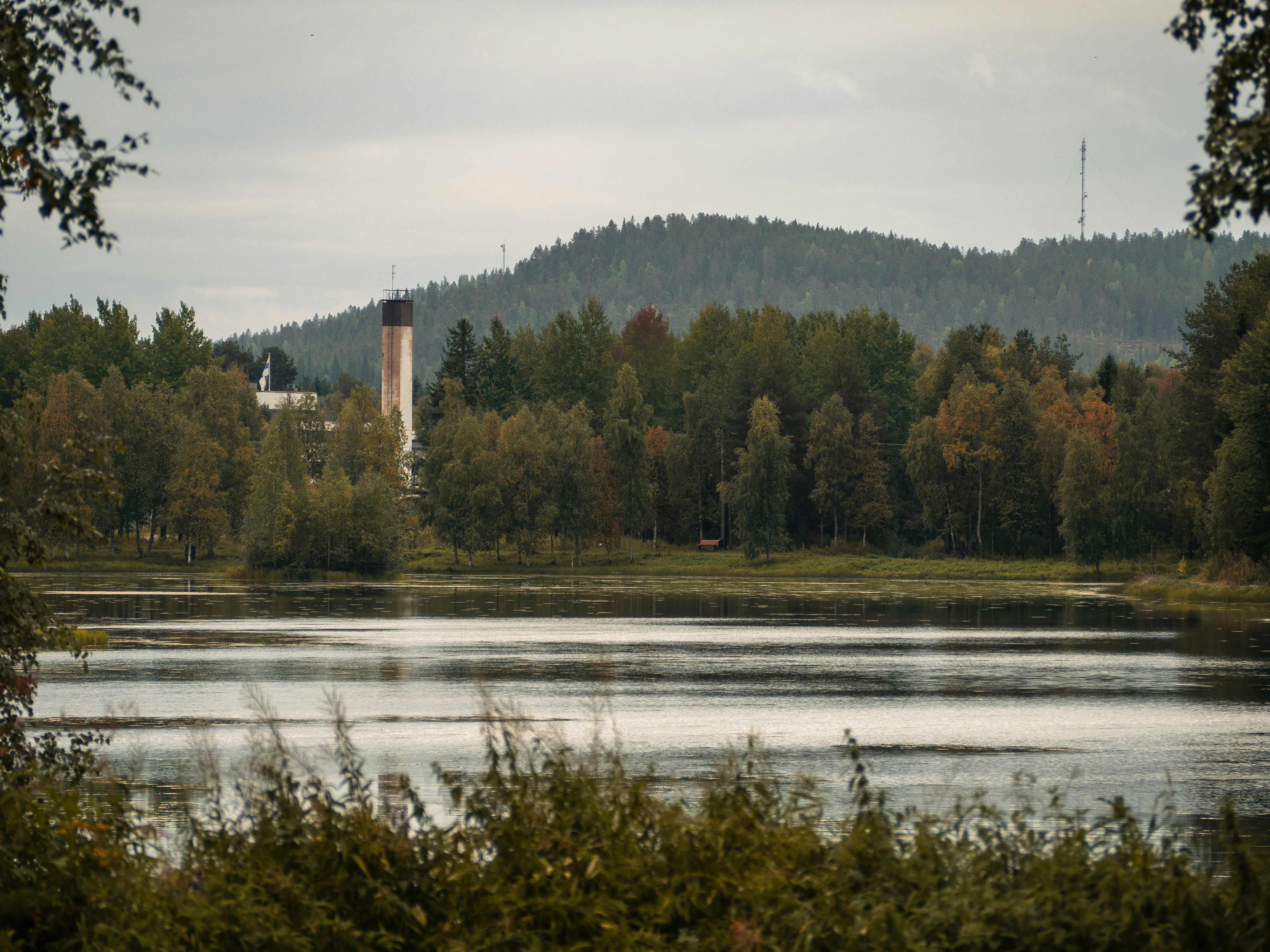 A body of water surrounded by trees and hills