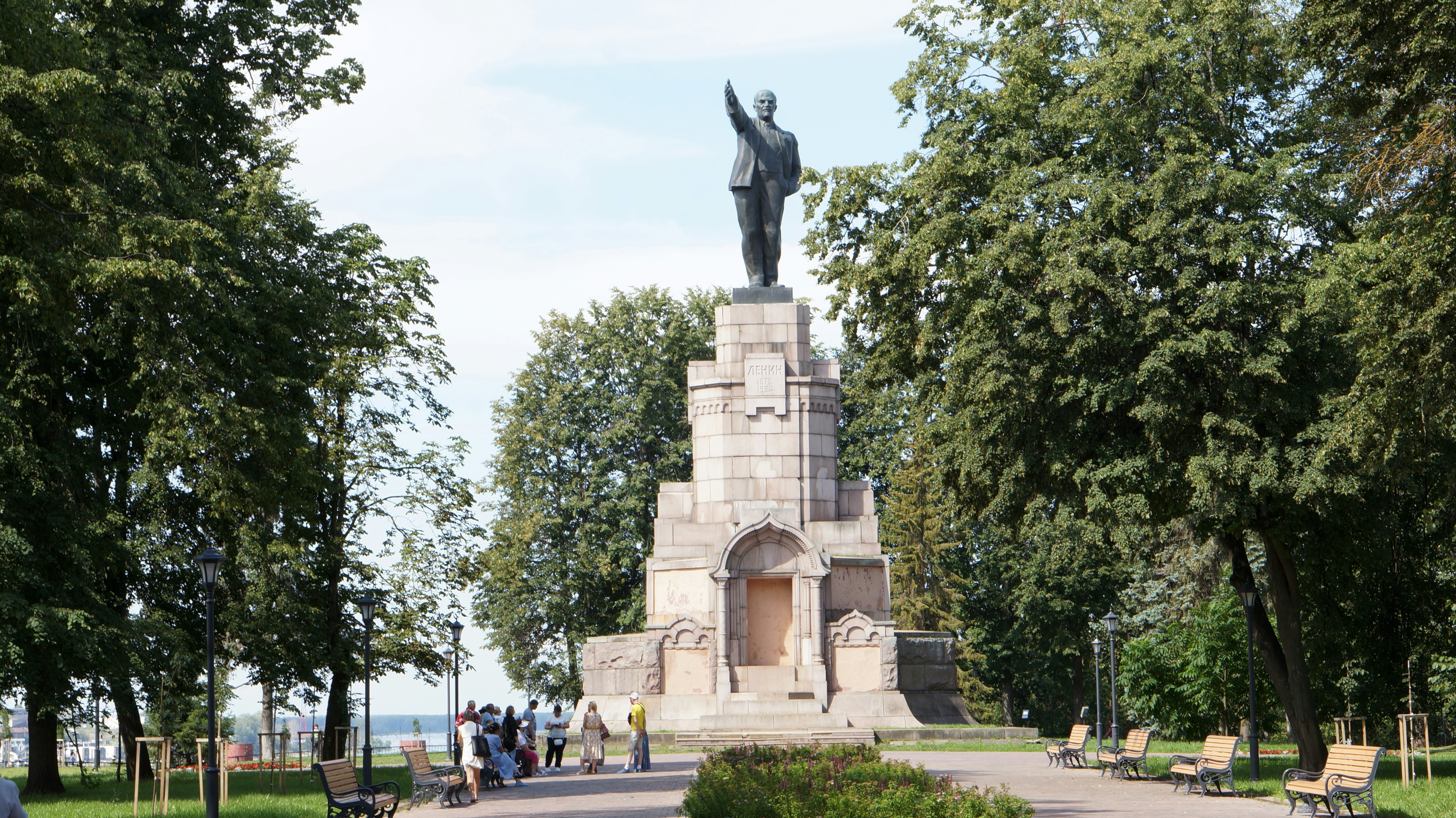 A statue of a man holding a bird in a park