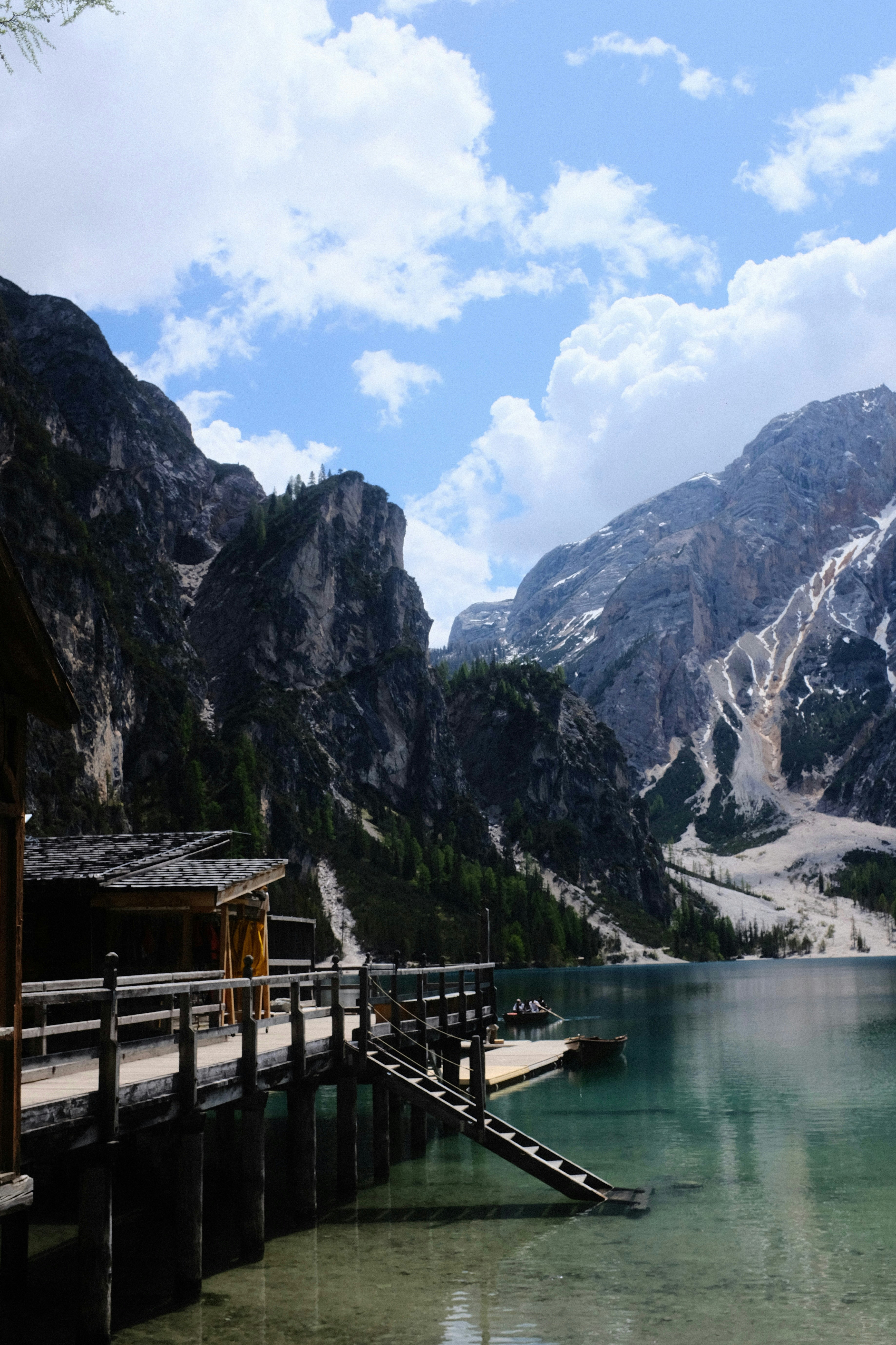 A wooden dock sitting on the side of a mountain lake