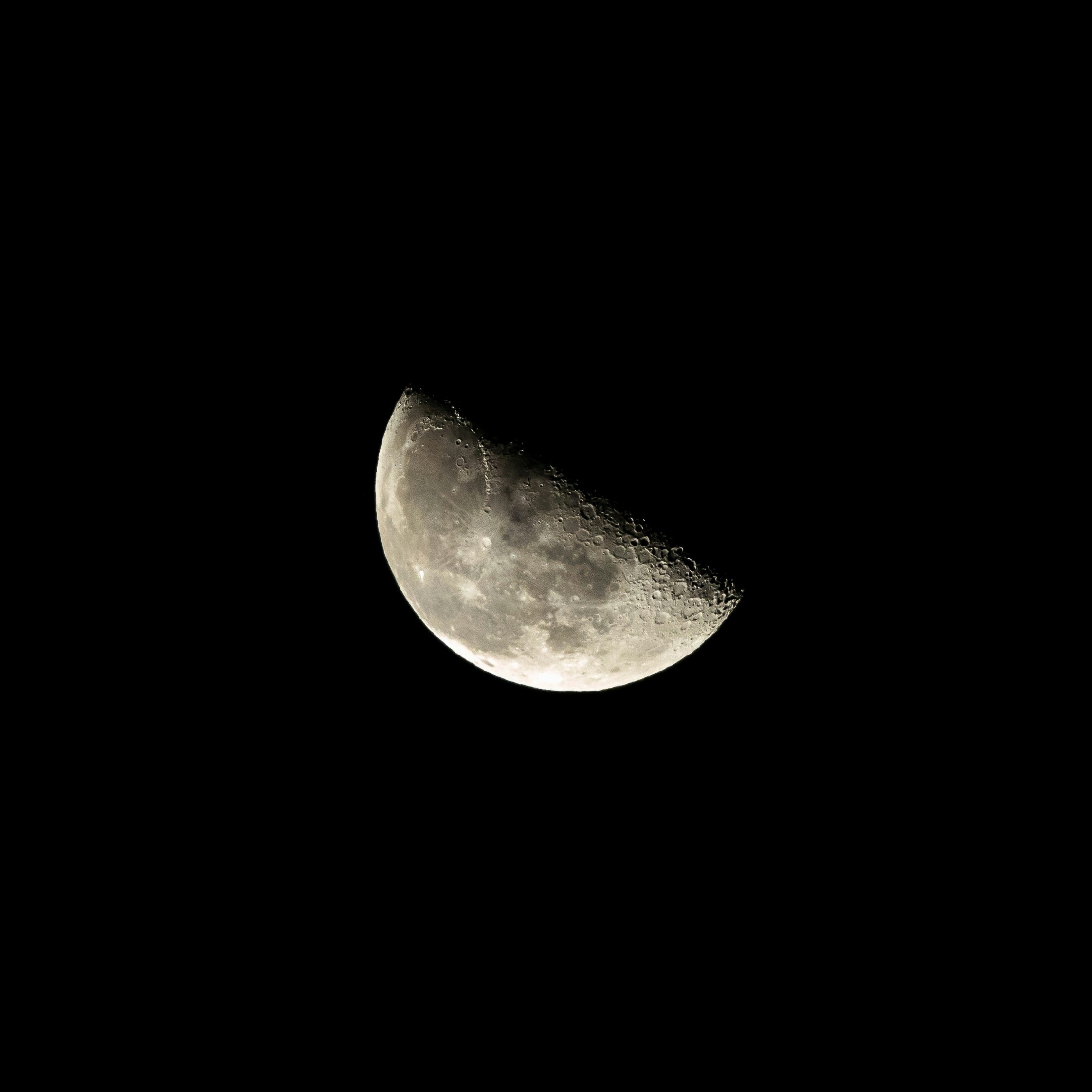 cratery last quarter moon, tipped sideways in a pitch black sky