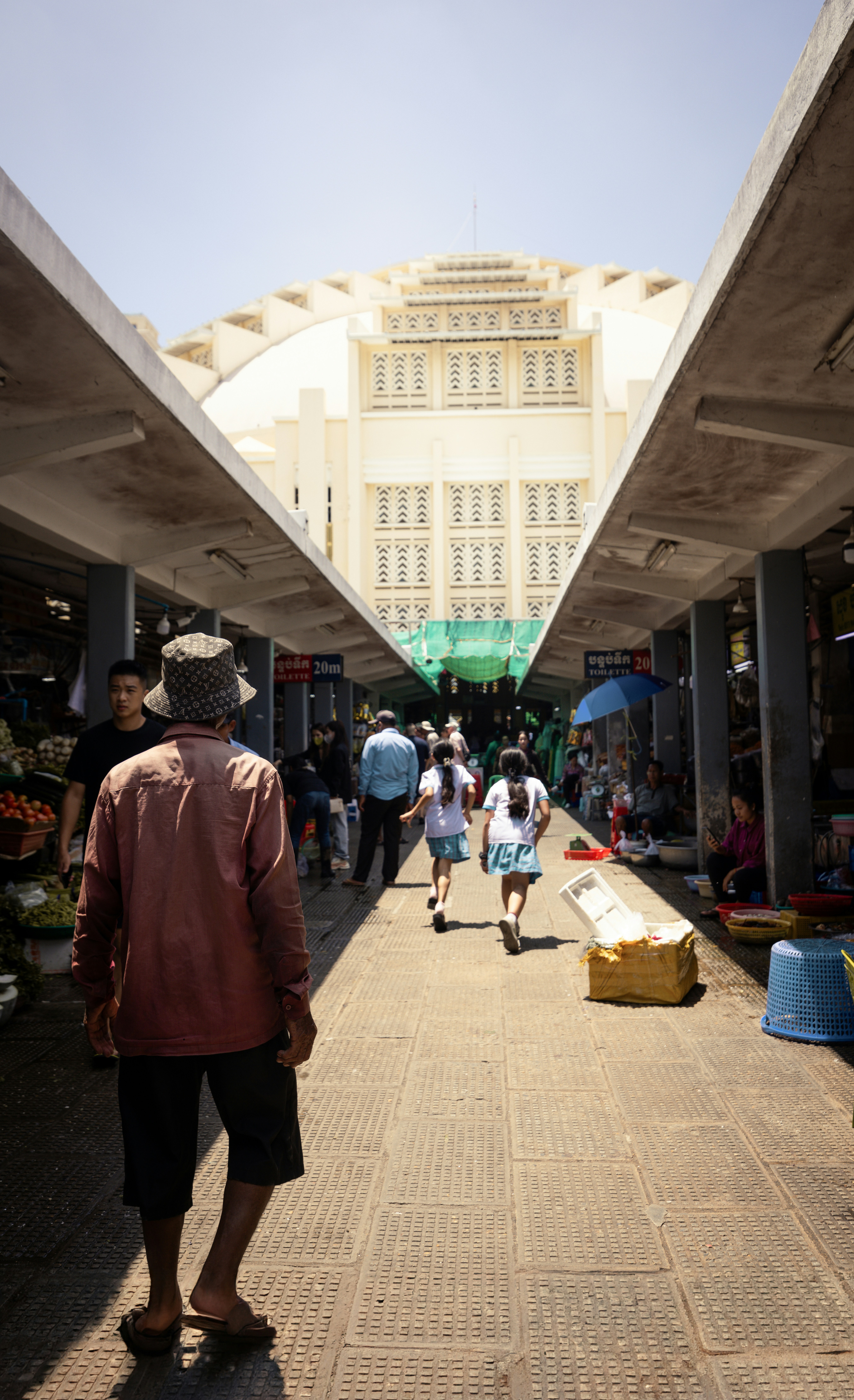 A group of people walking down a street next to a building