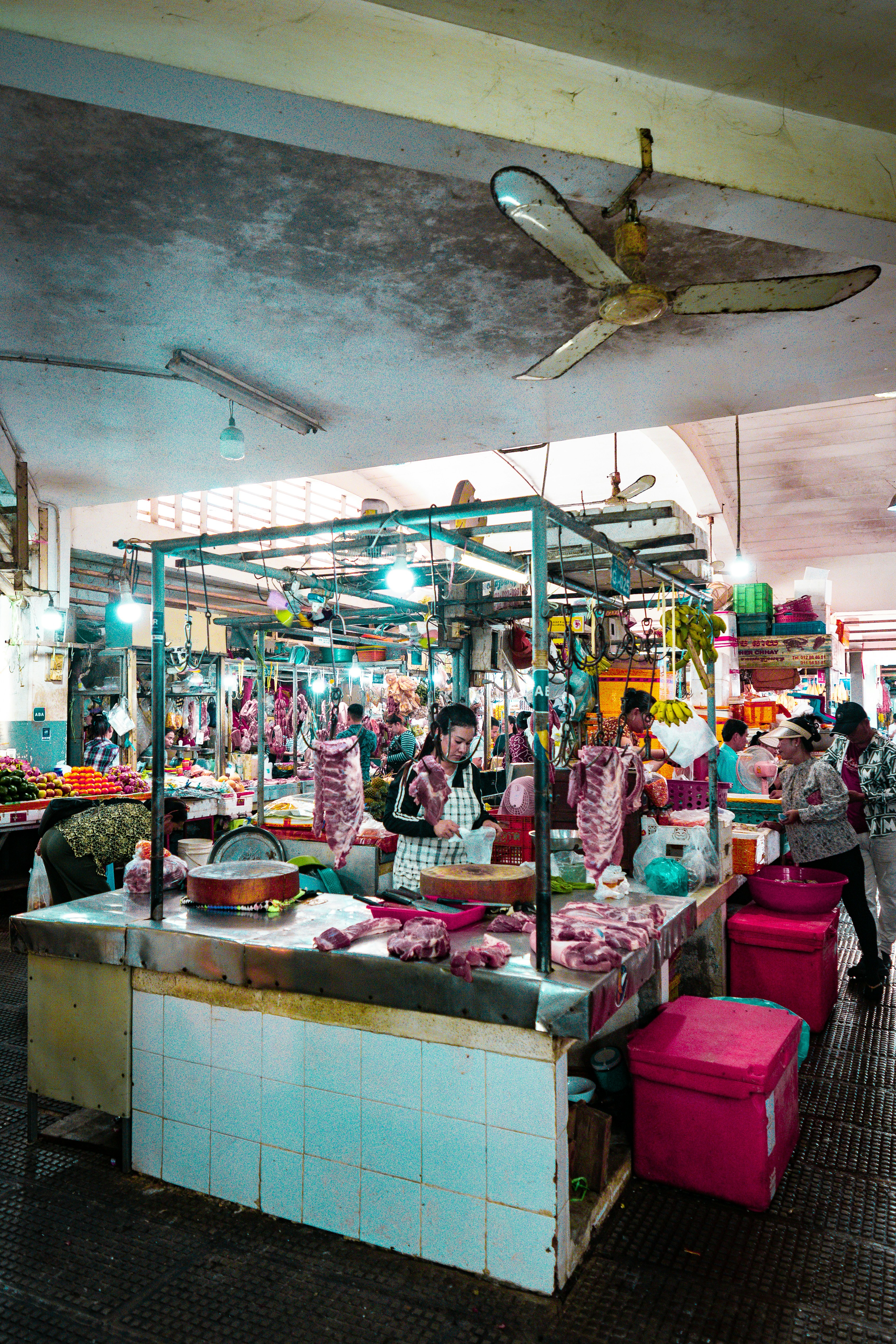A man standing in front of a store filled with lots of items