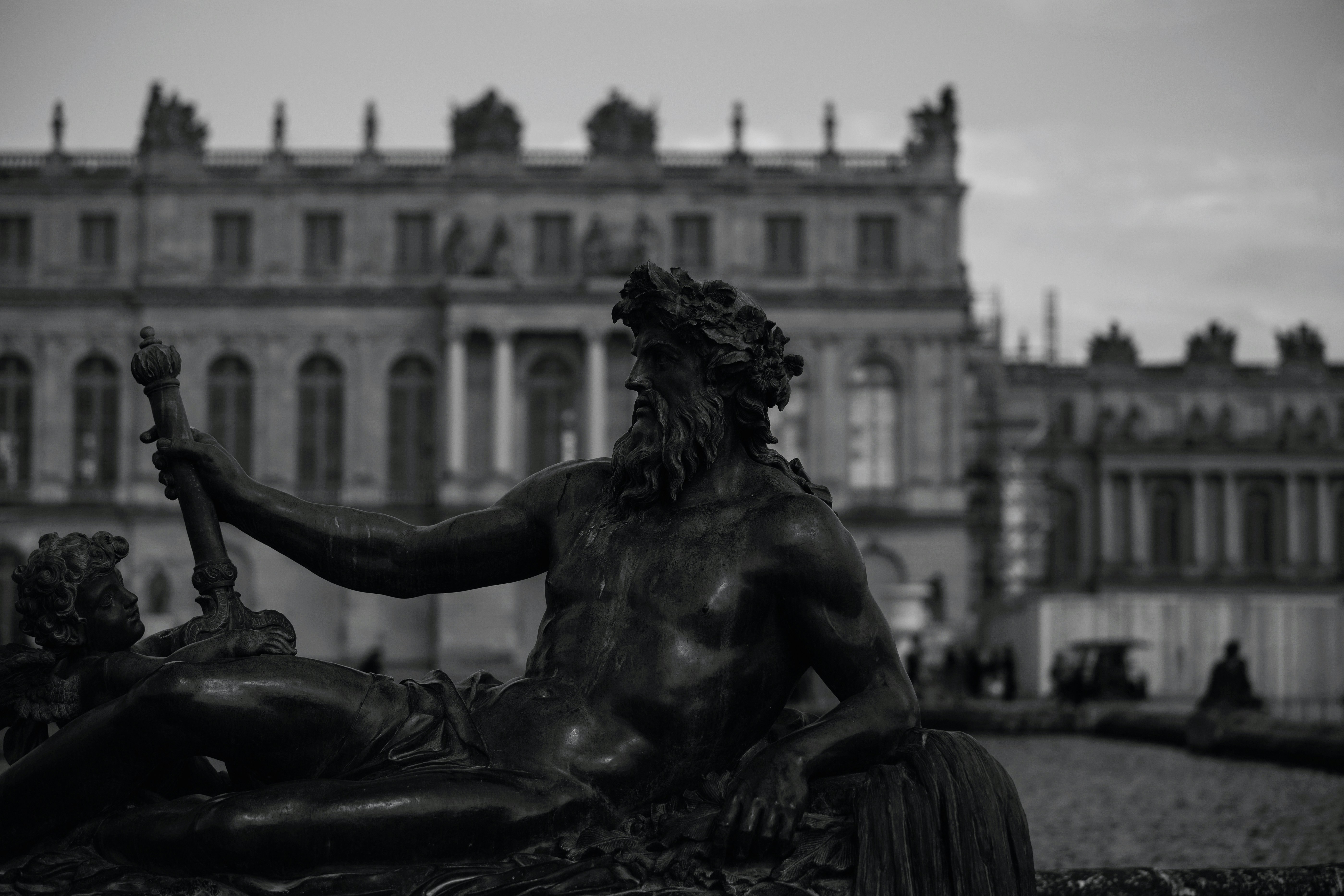 A black and white photo of a statue in front of a building