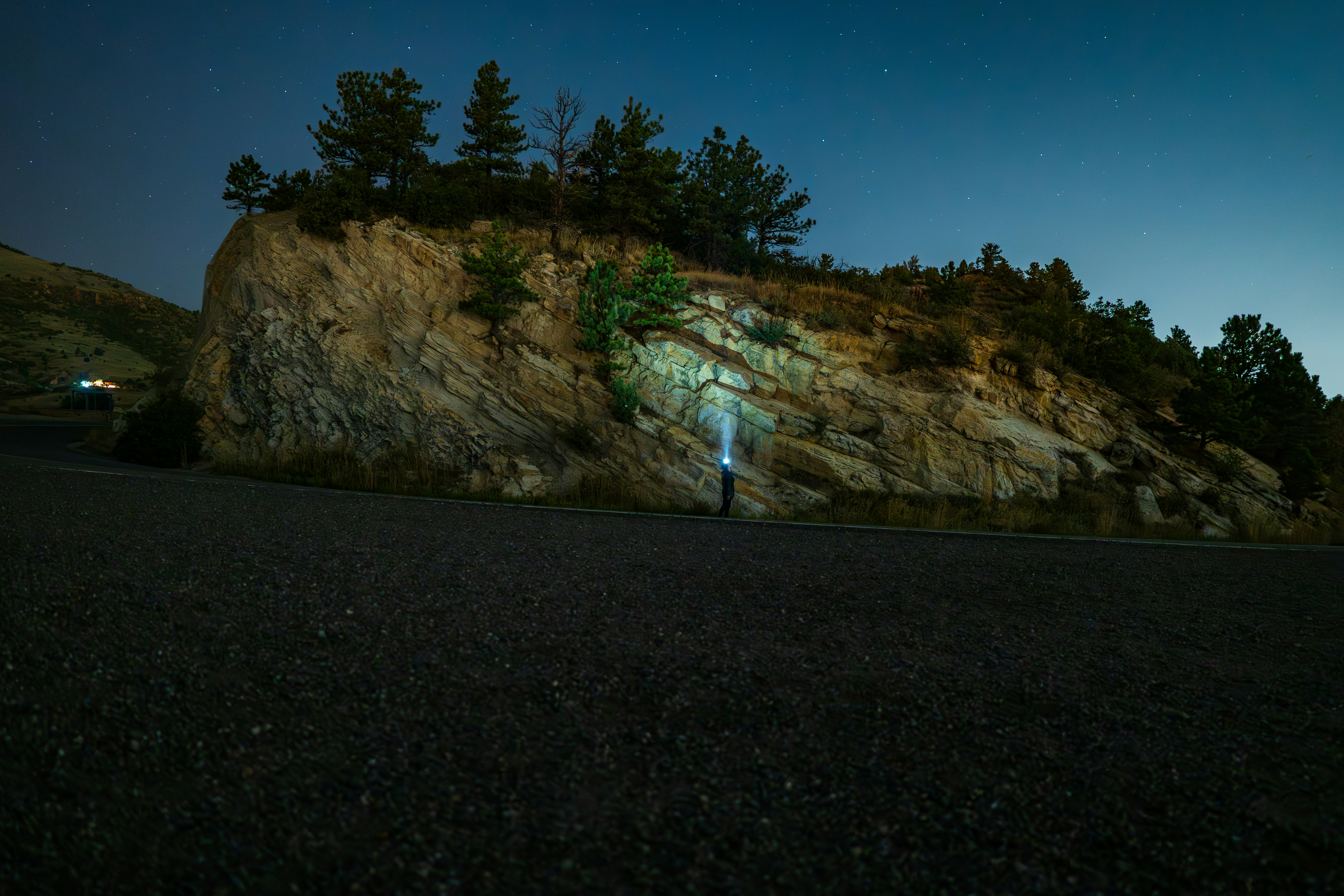 A person standing in the middle of a road at night