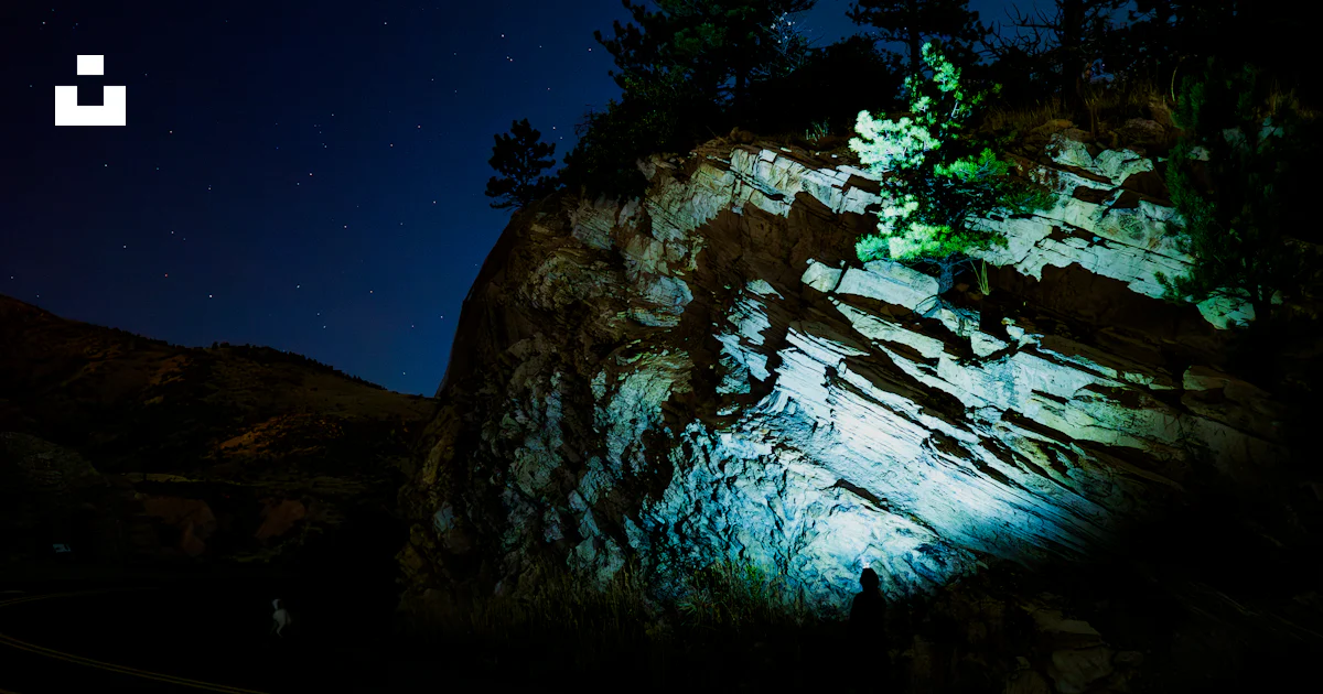 Night Rocks Images A rock with trees on it lit up at night photo – Free Night Image on ...