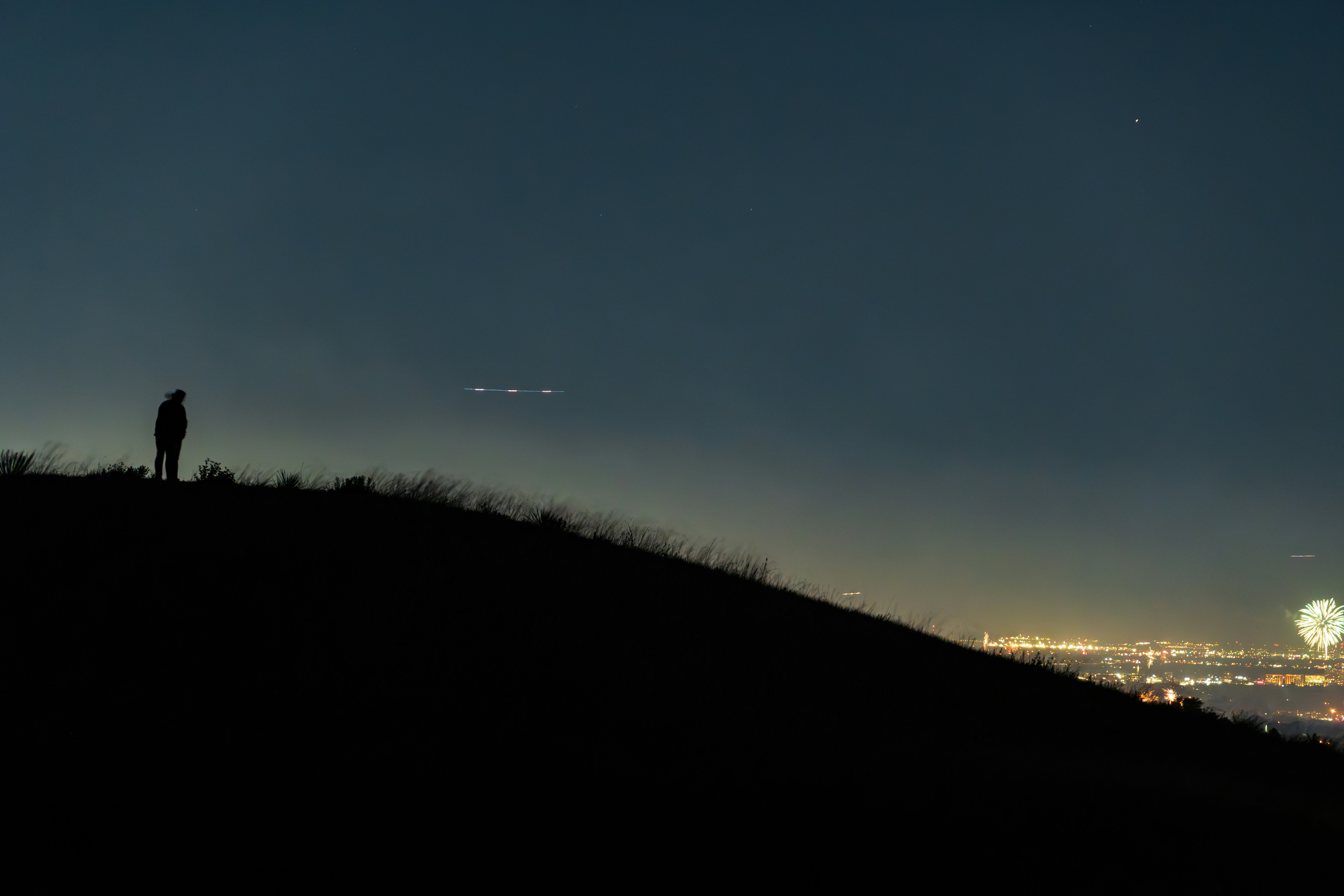 A couple of people standing on top of a hill