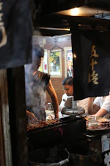 A group of people cooking food on top of a grill