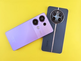 A camera and a cell phone on a yellow background