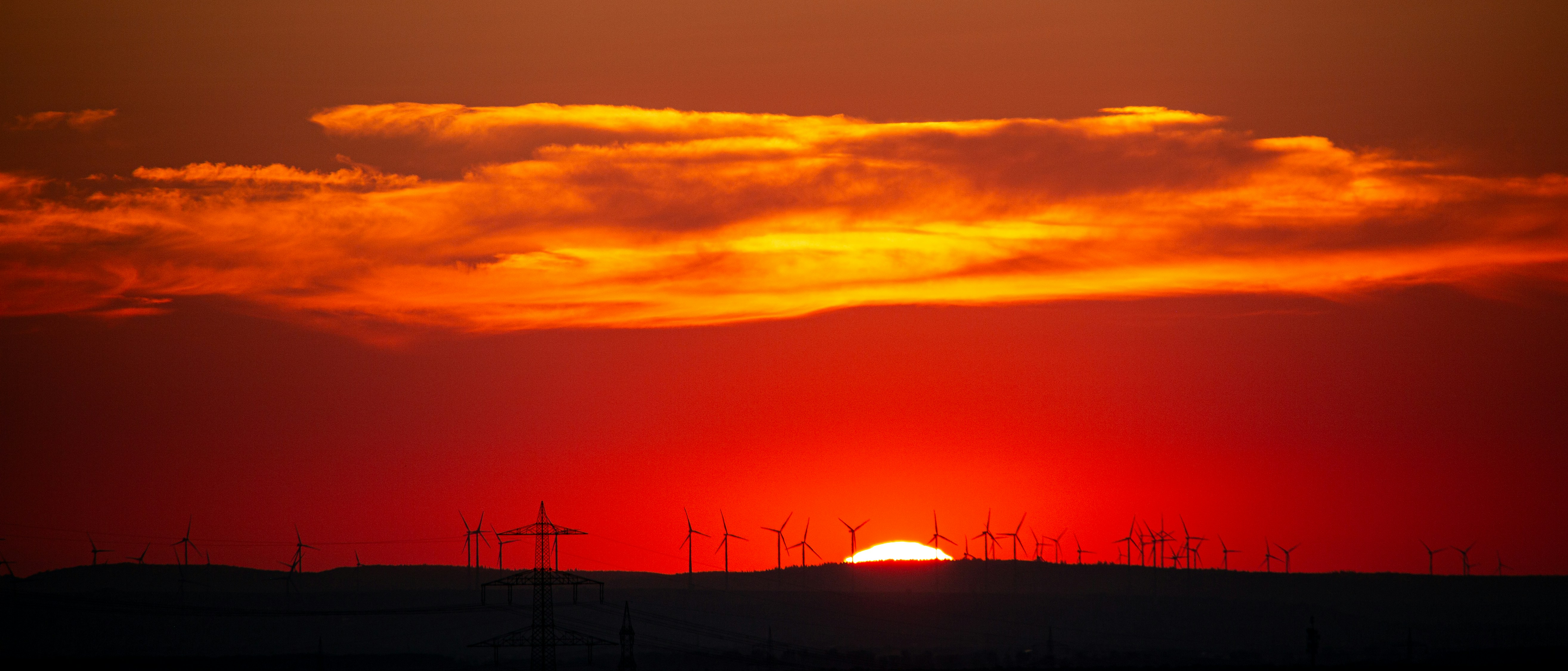 The sun is setting over the horizon of a field