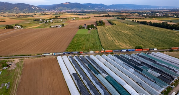 An aerial view of a farm with a train passing by