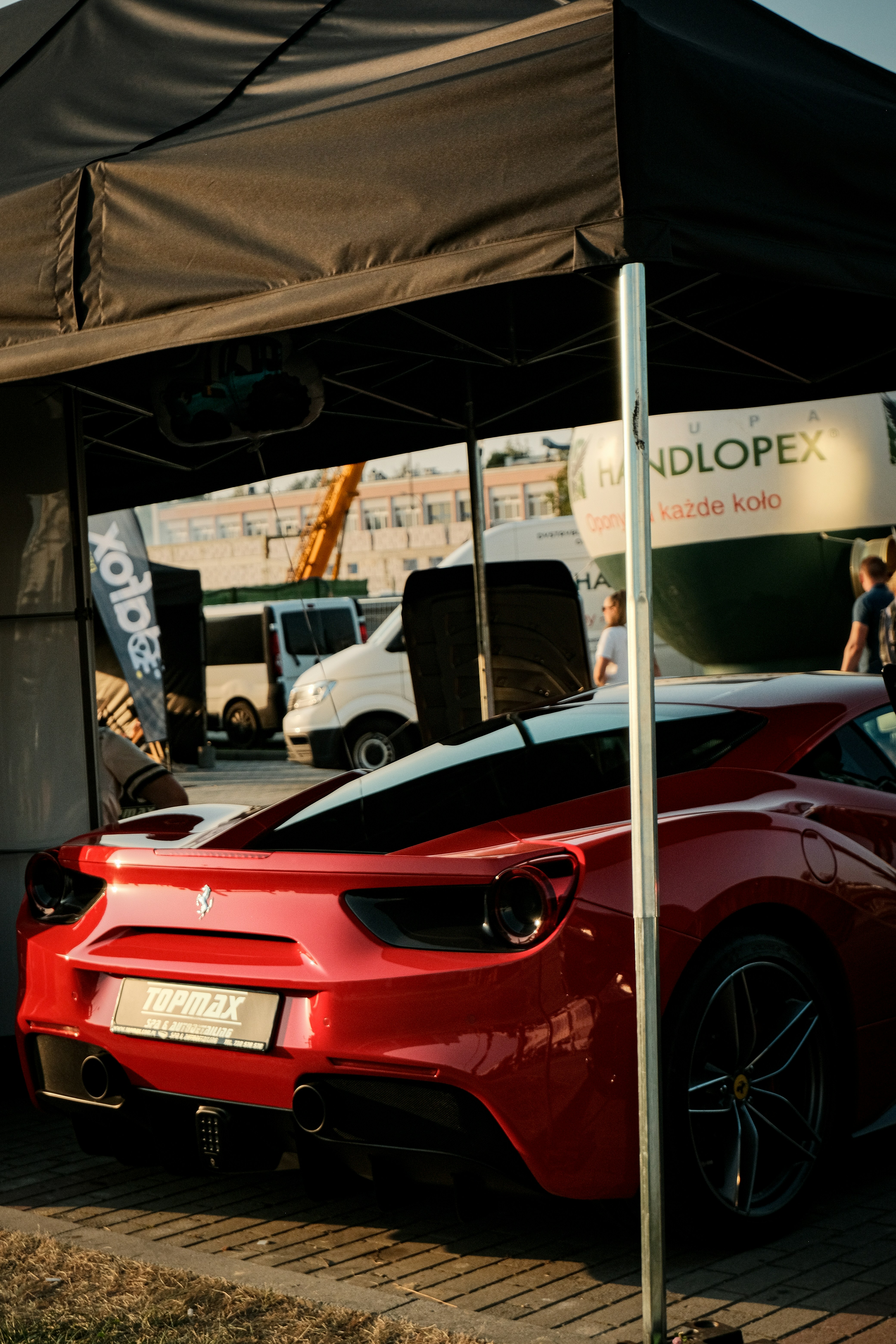 A red sports car parked in front of a tent