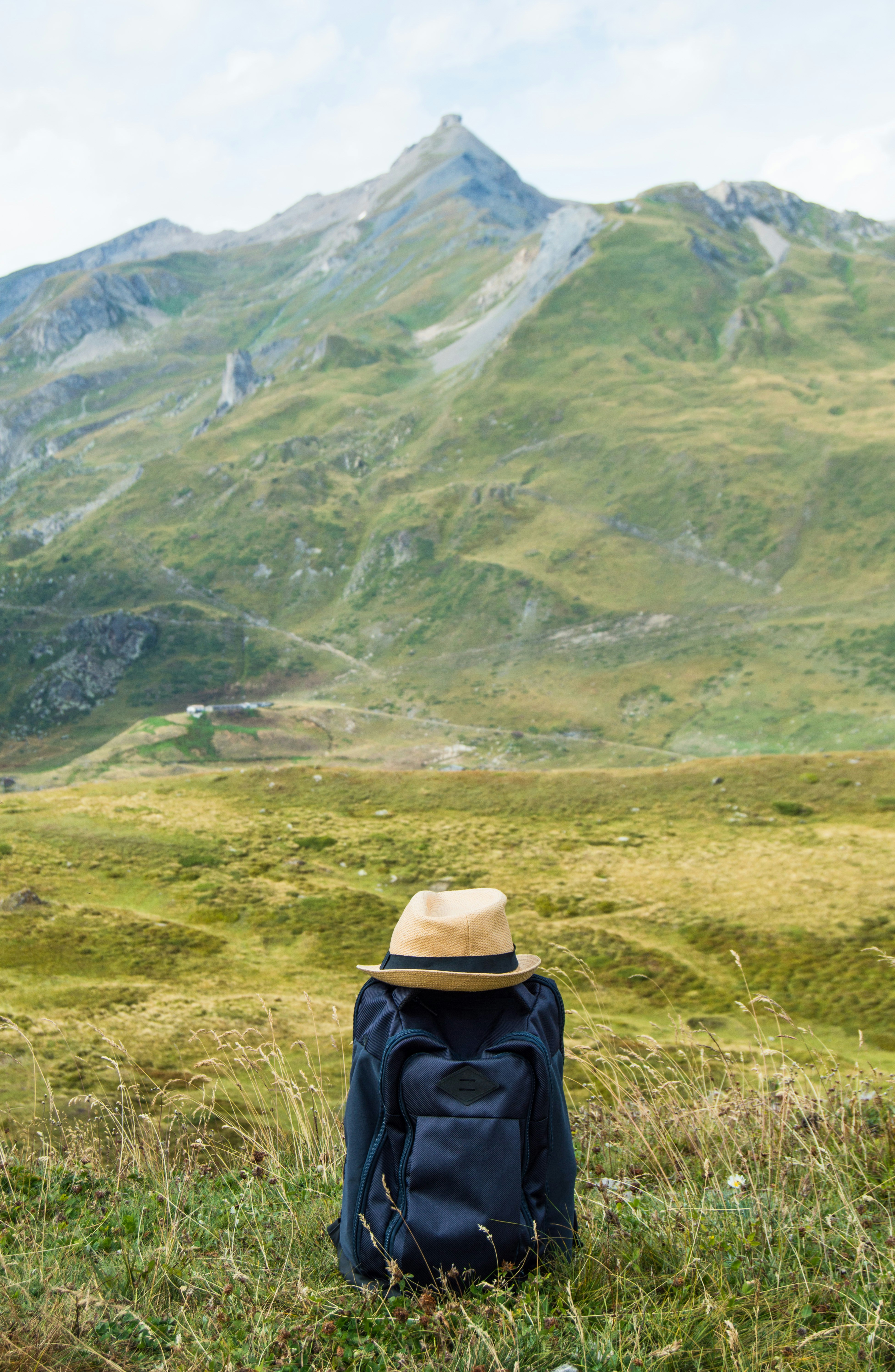 A backpack sitting in the grass with a mountain in the background