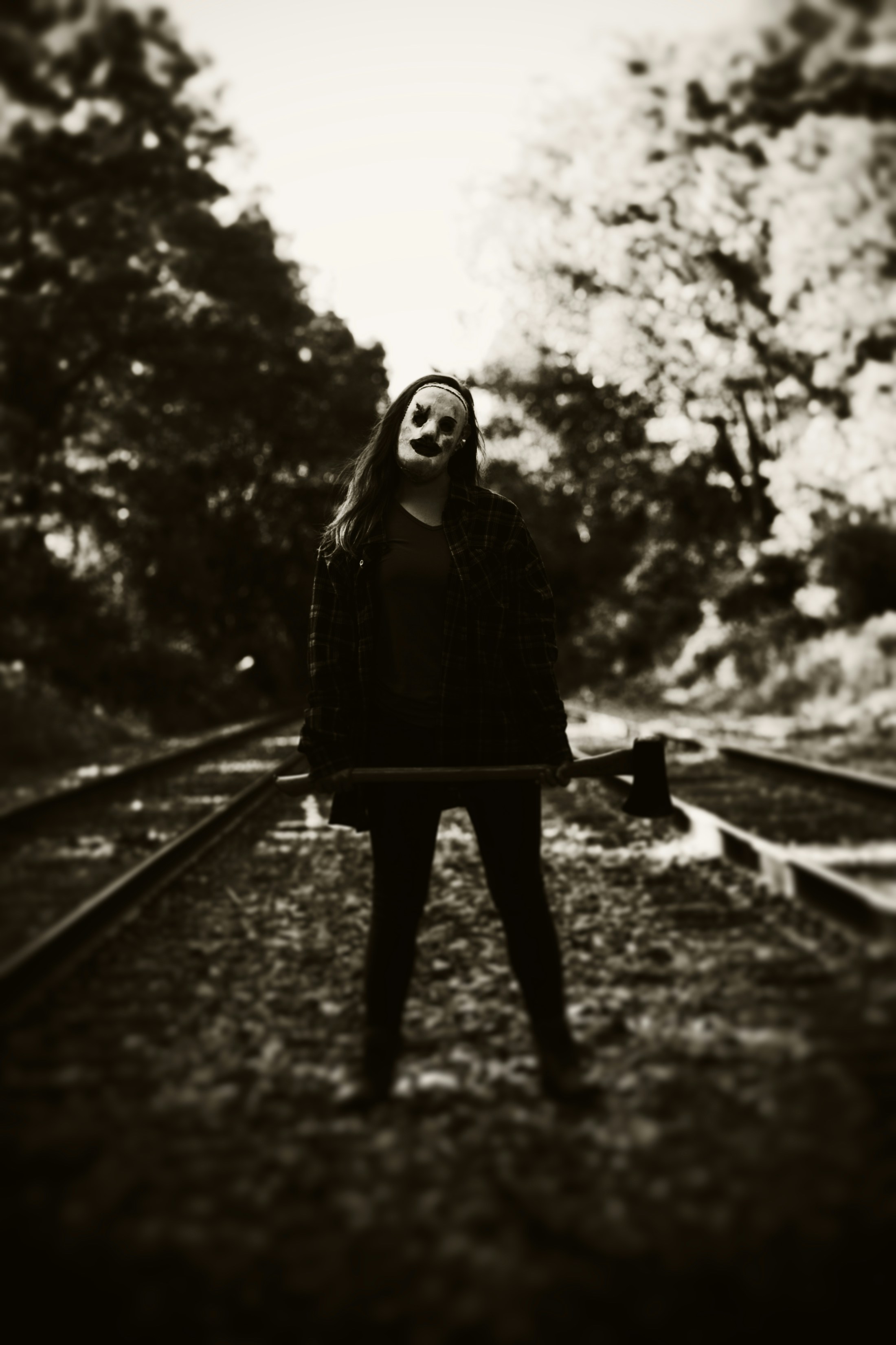 A person standing on a train track with a mask on