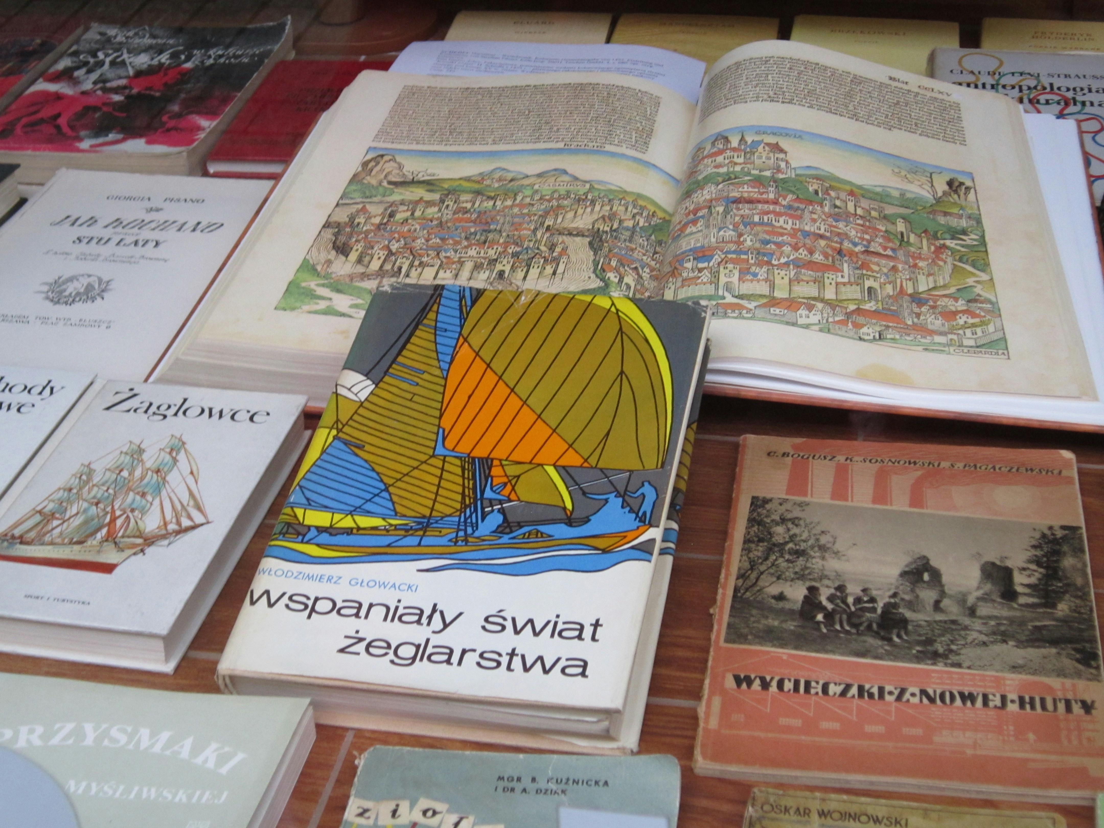 A table topped with lots of books on top of a wooden table