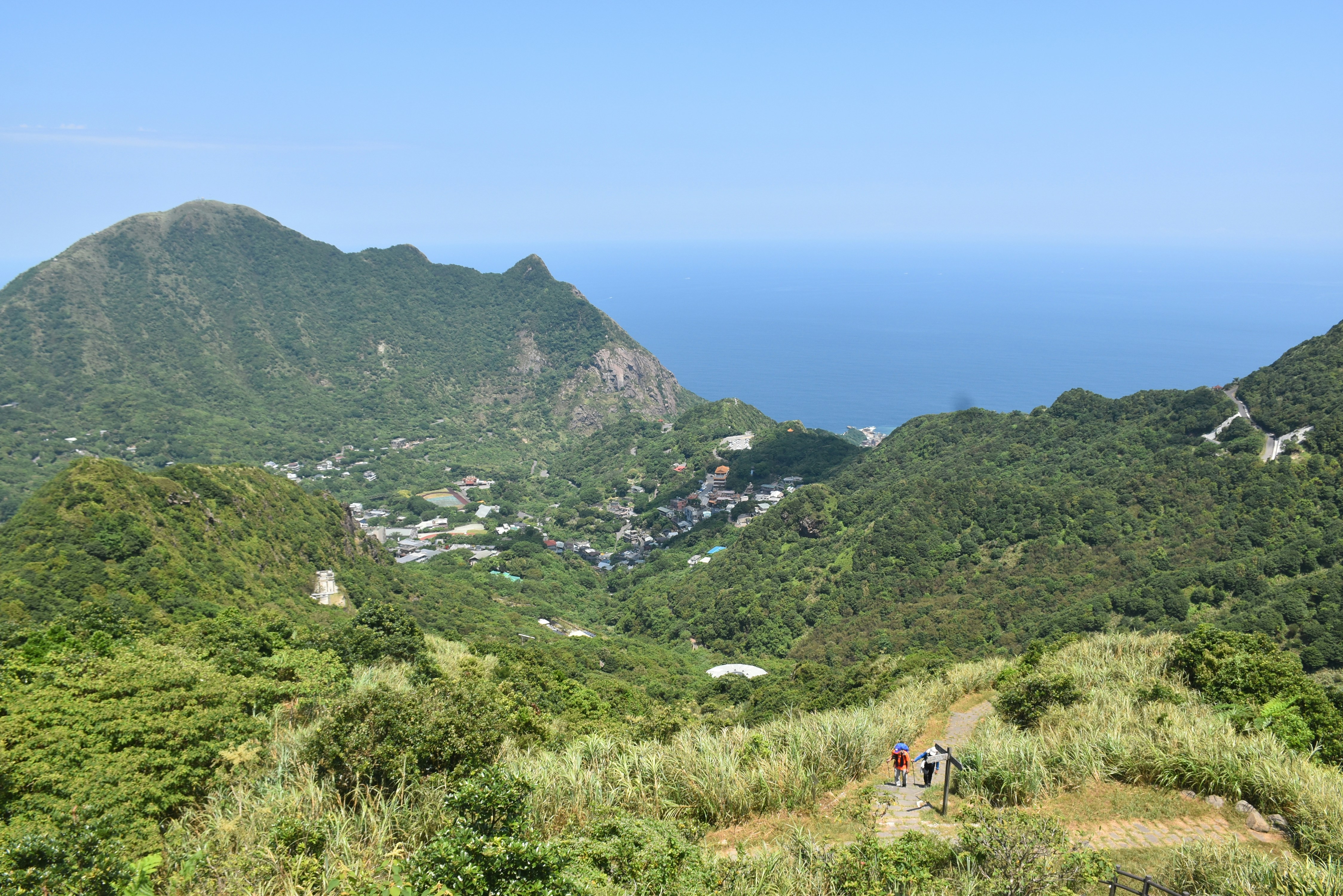 A couple of people walking up a hill