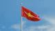 A chinese flag flying high in the sky