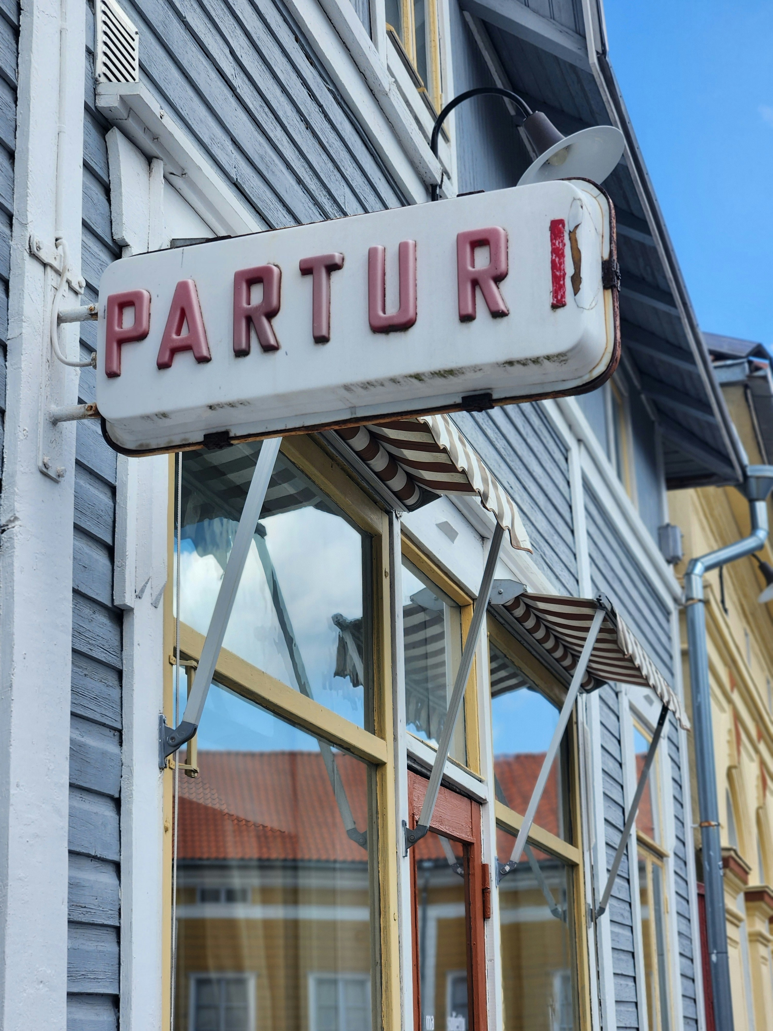 A sign that is hanging from the side of a building