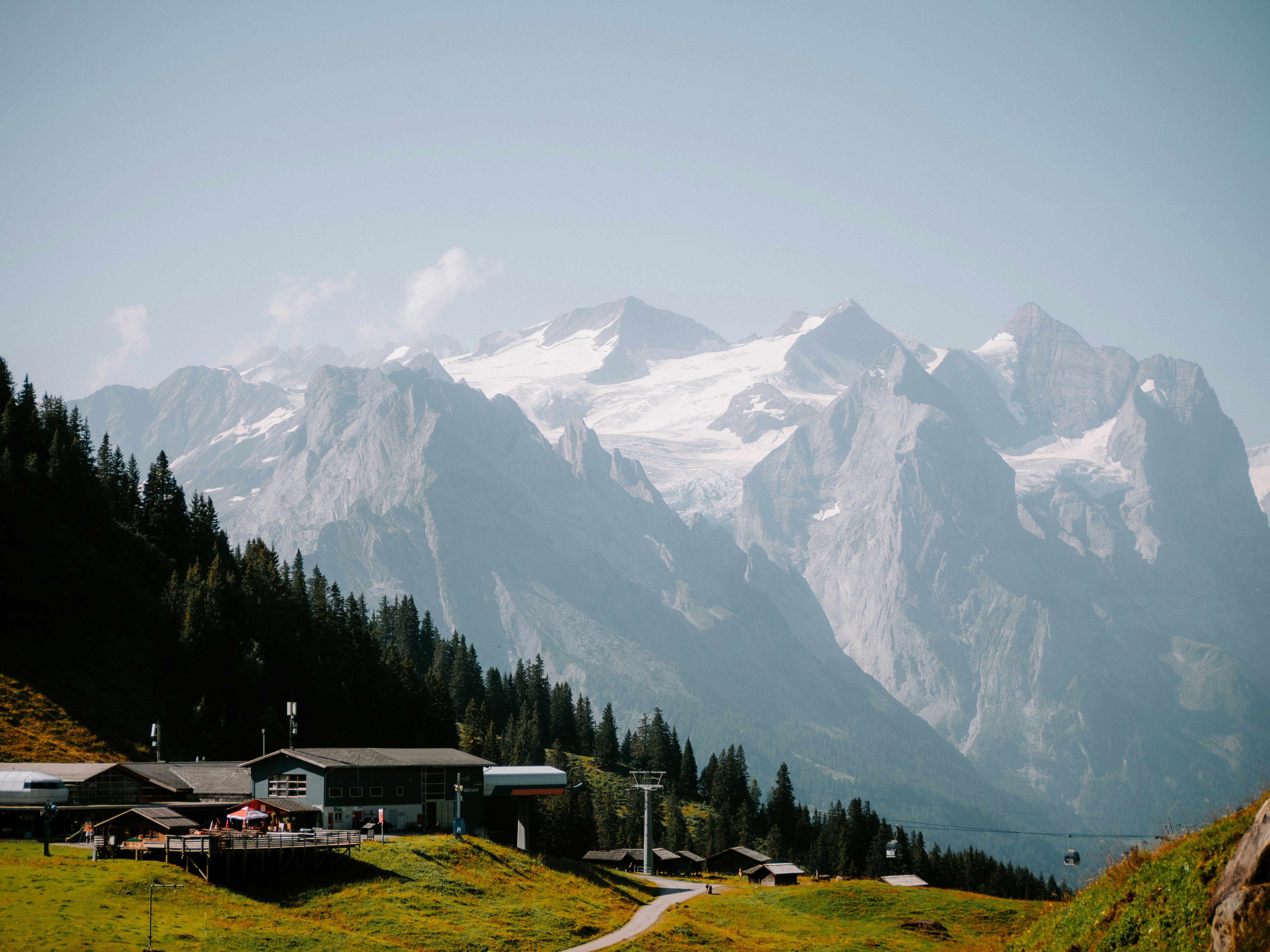 A view of a mountain range with a house in the foreground, 