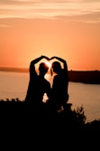 Two people making a heart shape with their hands