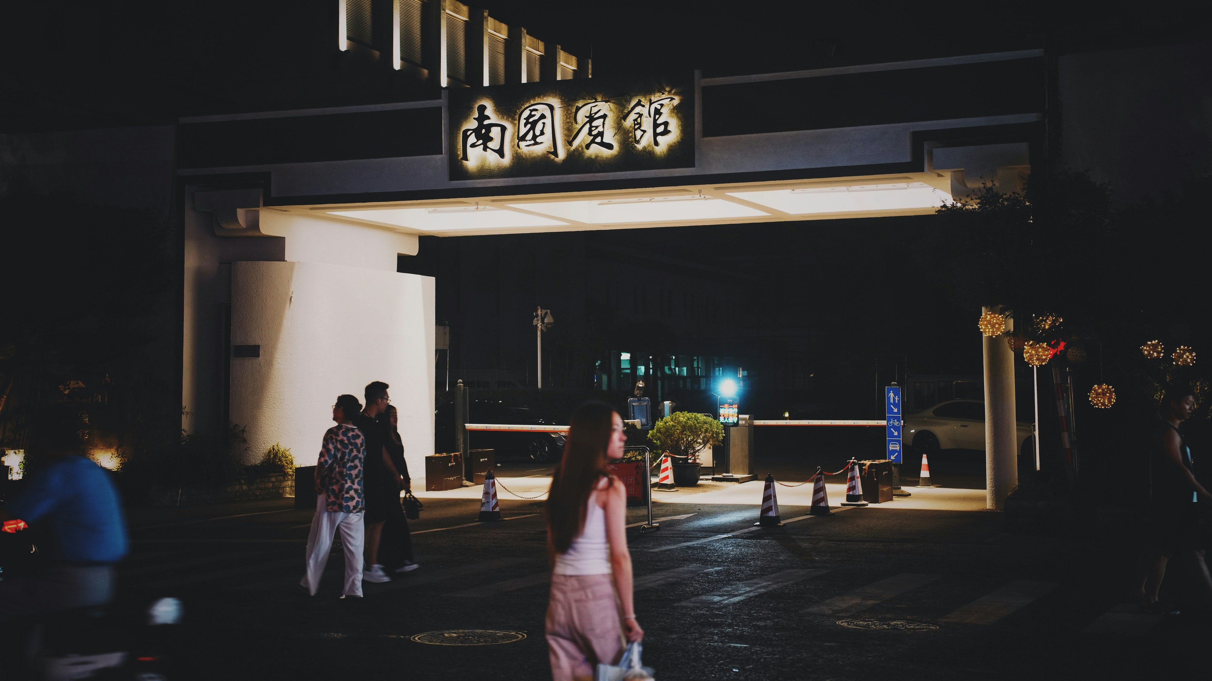 A group of people standing outside of a building at night