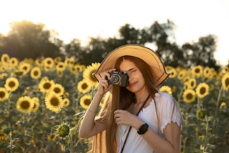A woman taking a picture of a field of sunflowers