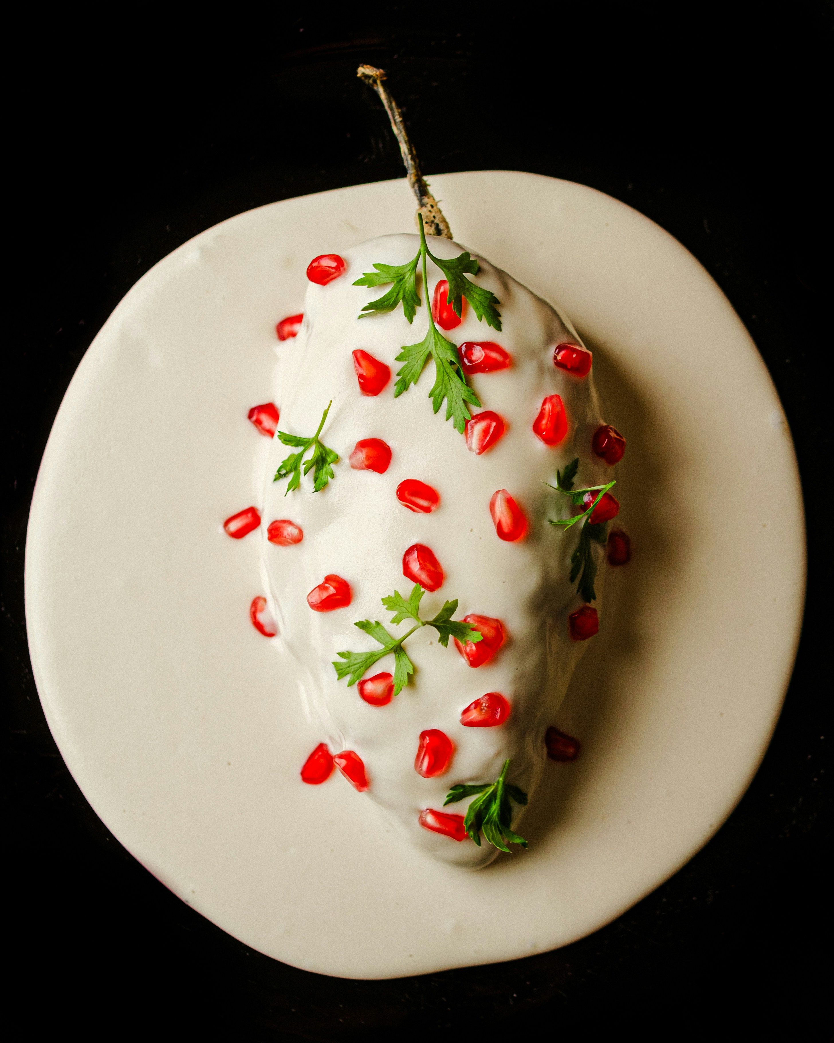 A white plate topped with a piece of cake covered in cherries