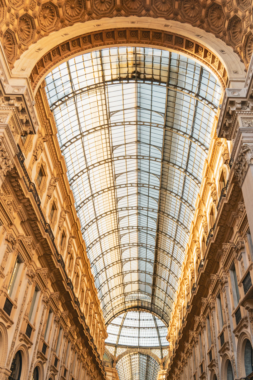 Grand hallway with large glass ceiling featuring arched windows and ornate architectural details