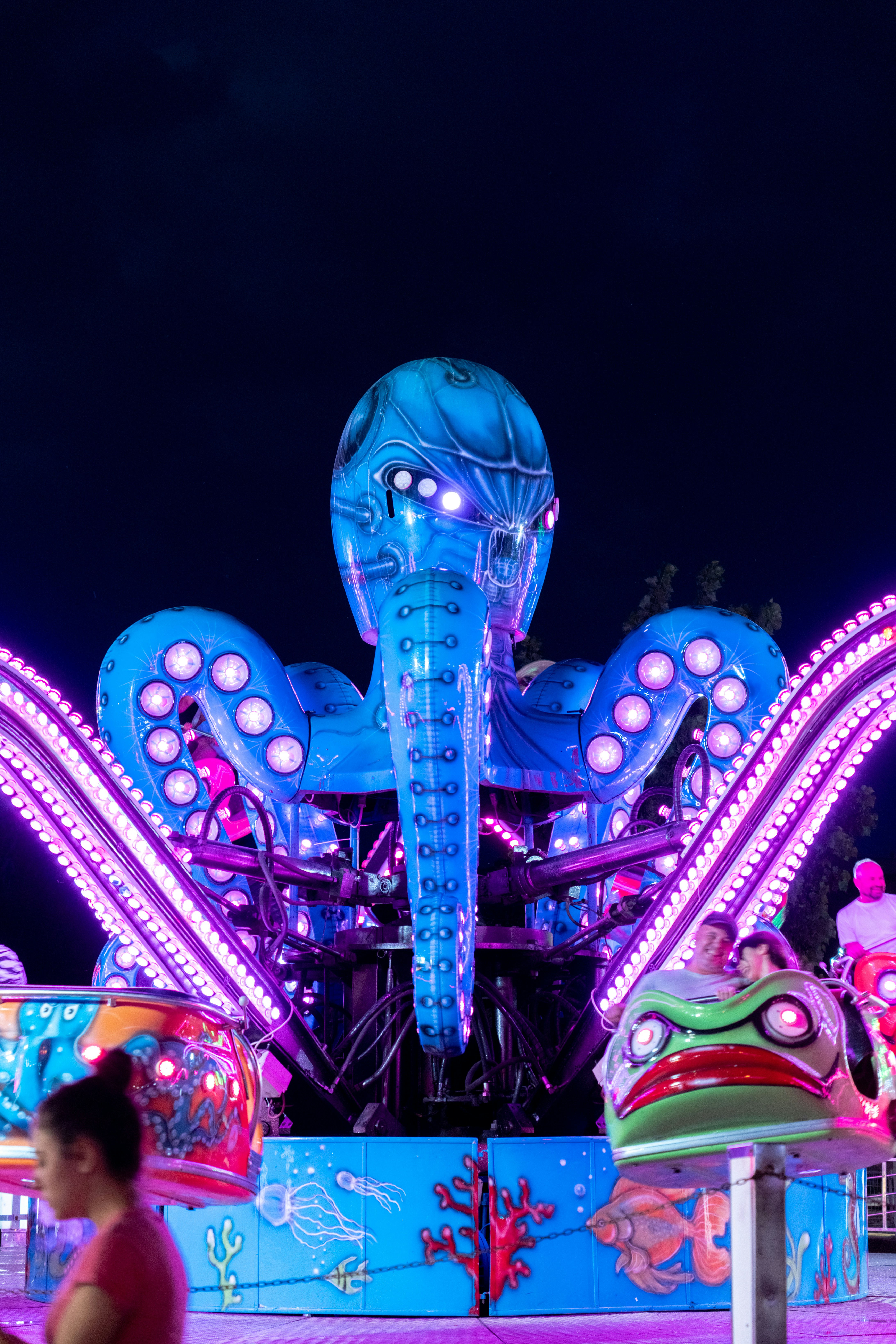 A carnival ride at night with people walking around photo – Free ...