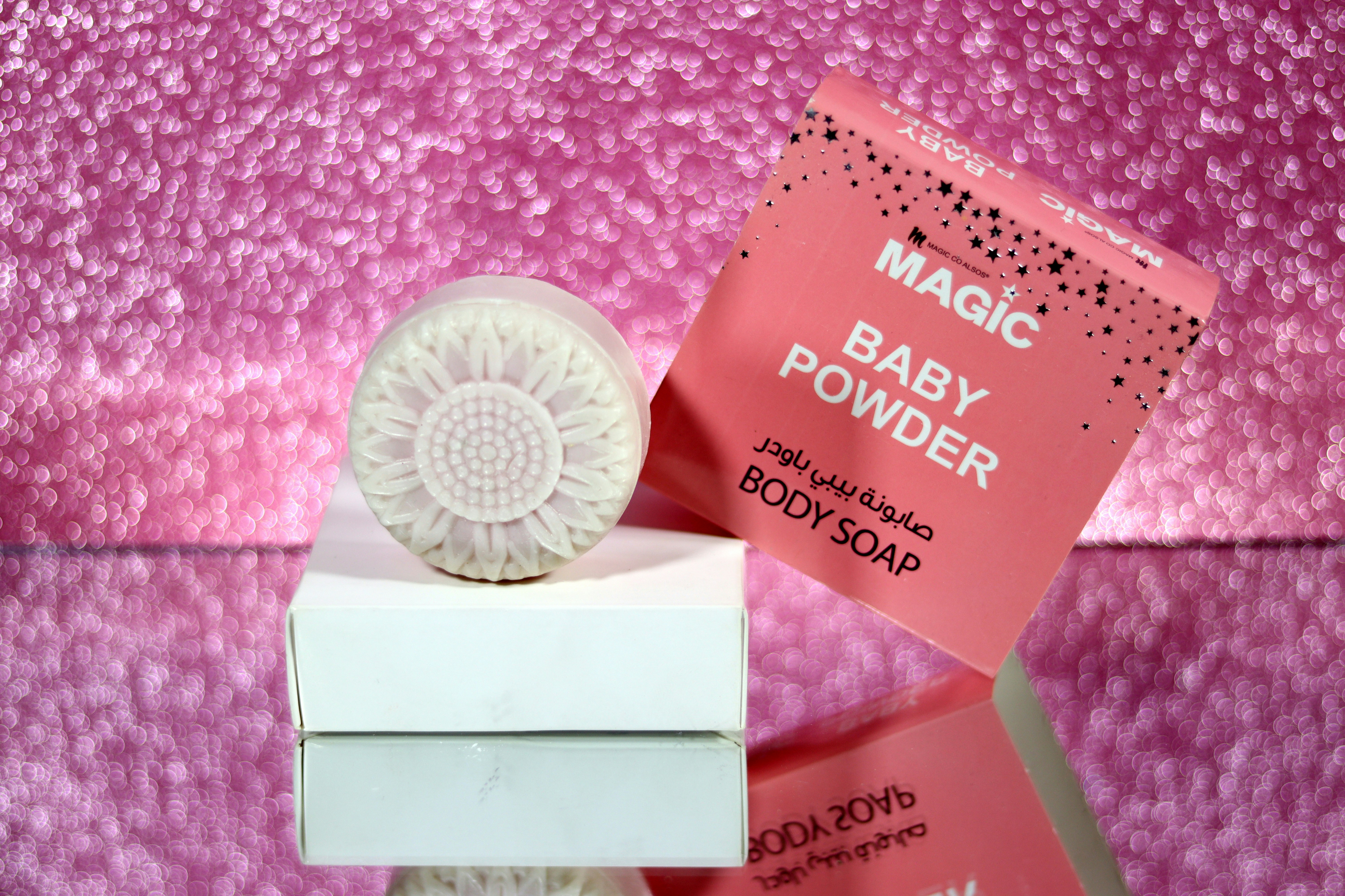 Luxury soap packaging in blush pink box with gold AROMEVA logo, elegant gift presentation on white surface with rose petals