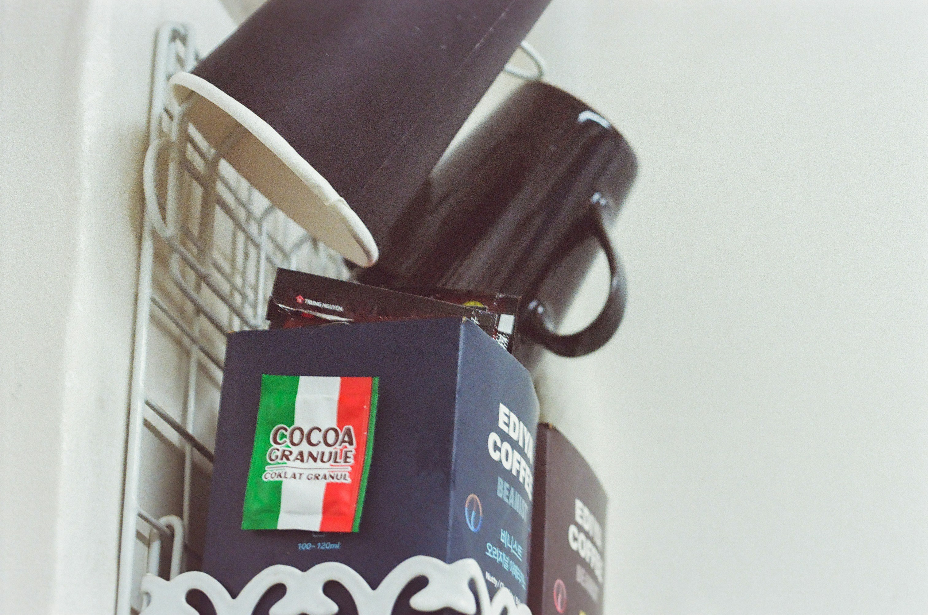 A black umbrella is hanging on a white wall