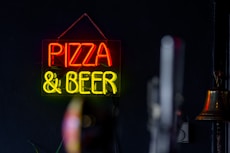 A neon sign that says pizza and beer