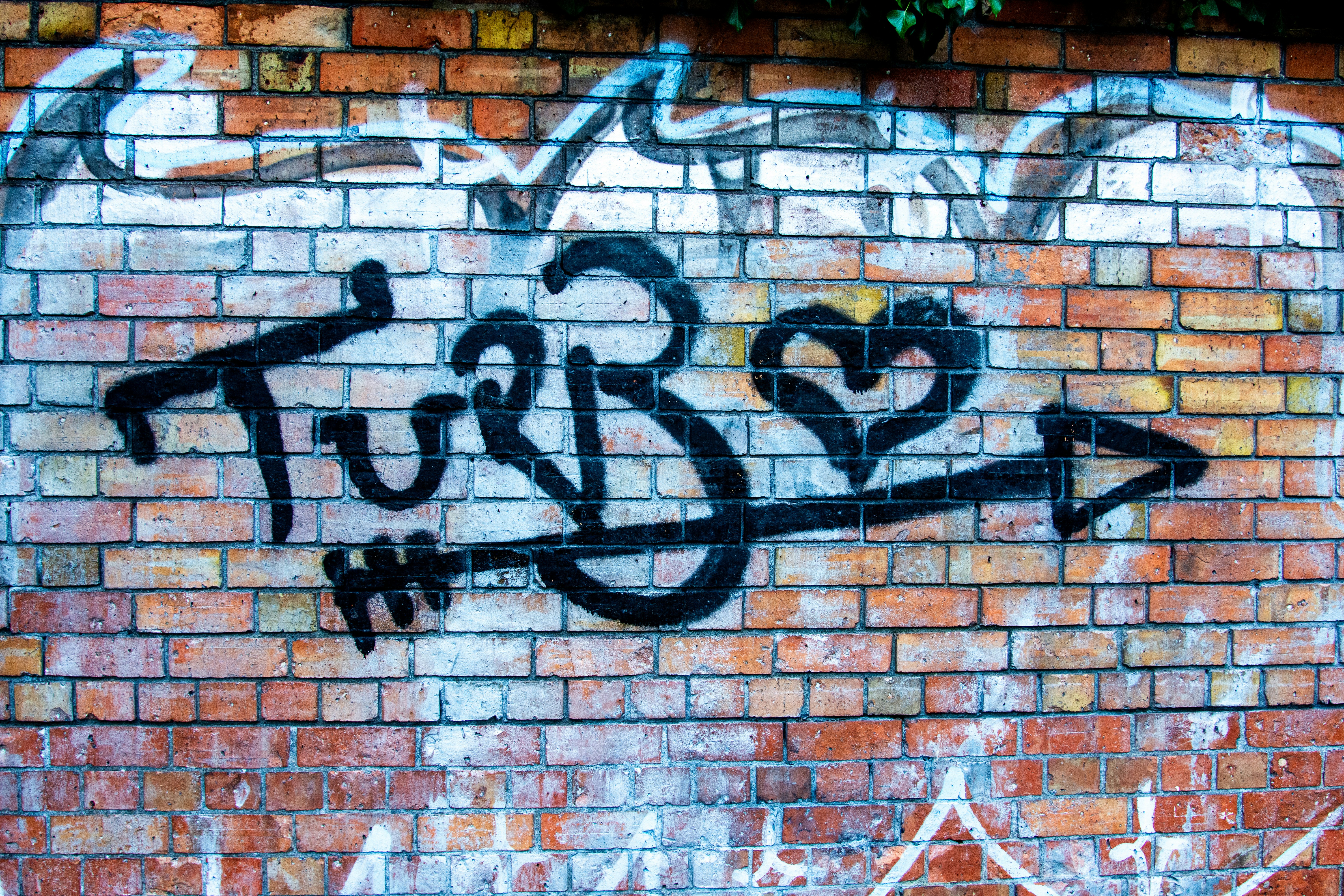 A brick wall with some graffiti on it