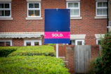 A sold sign in front of a brick building