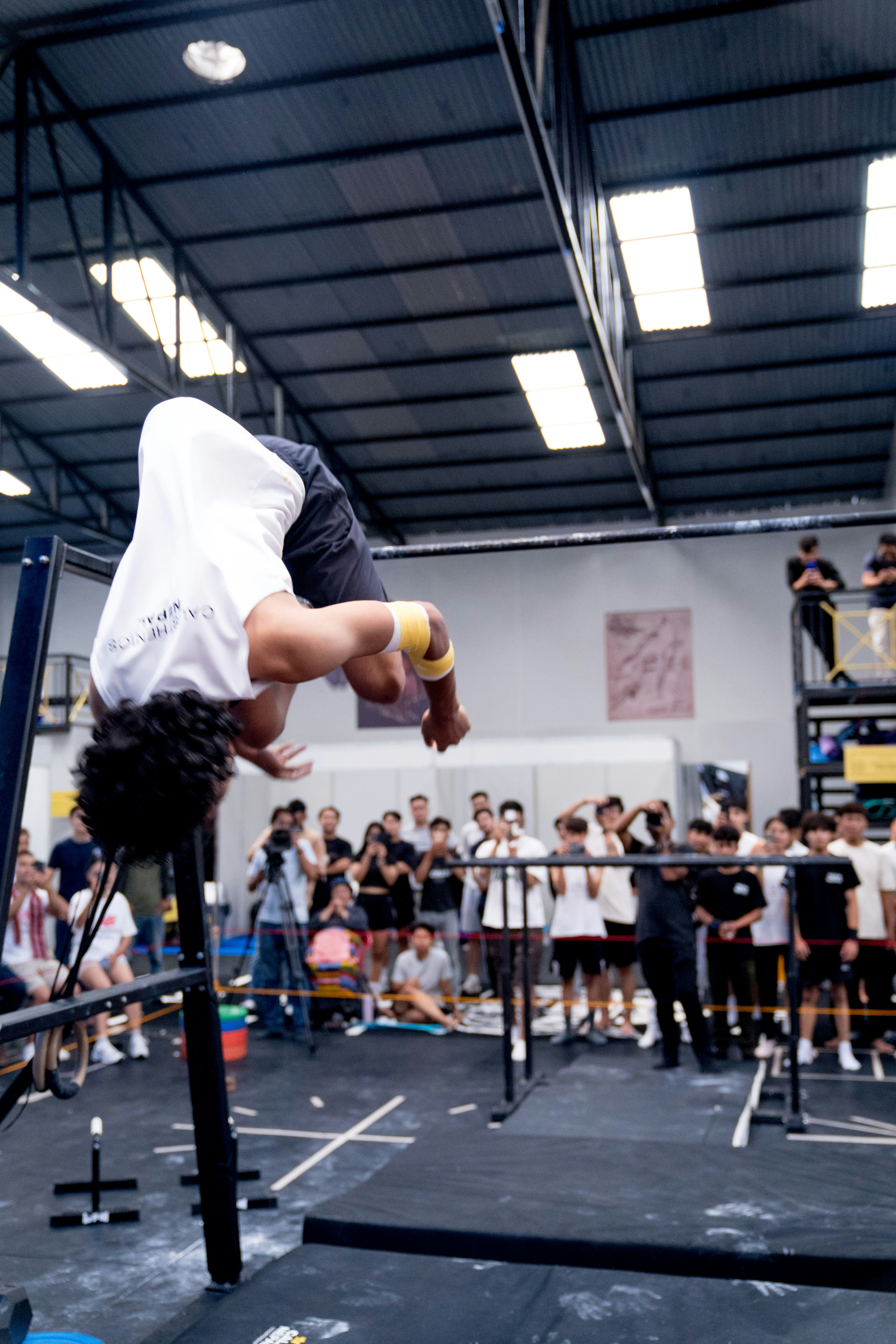 Seorang pria melakukan handstand di bar di gym