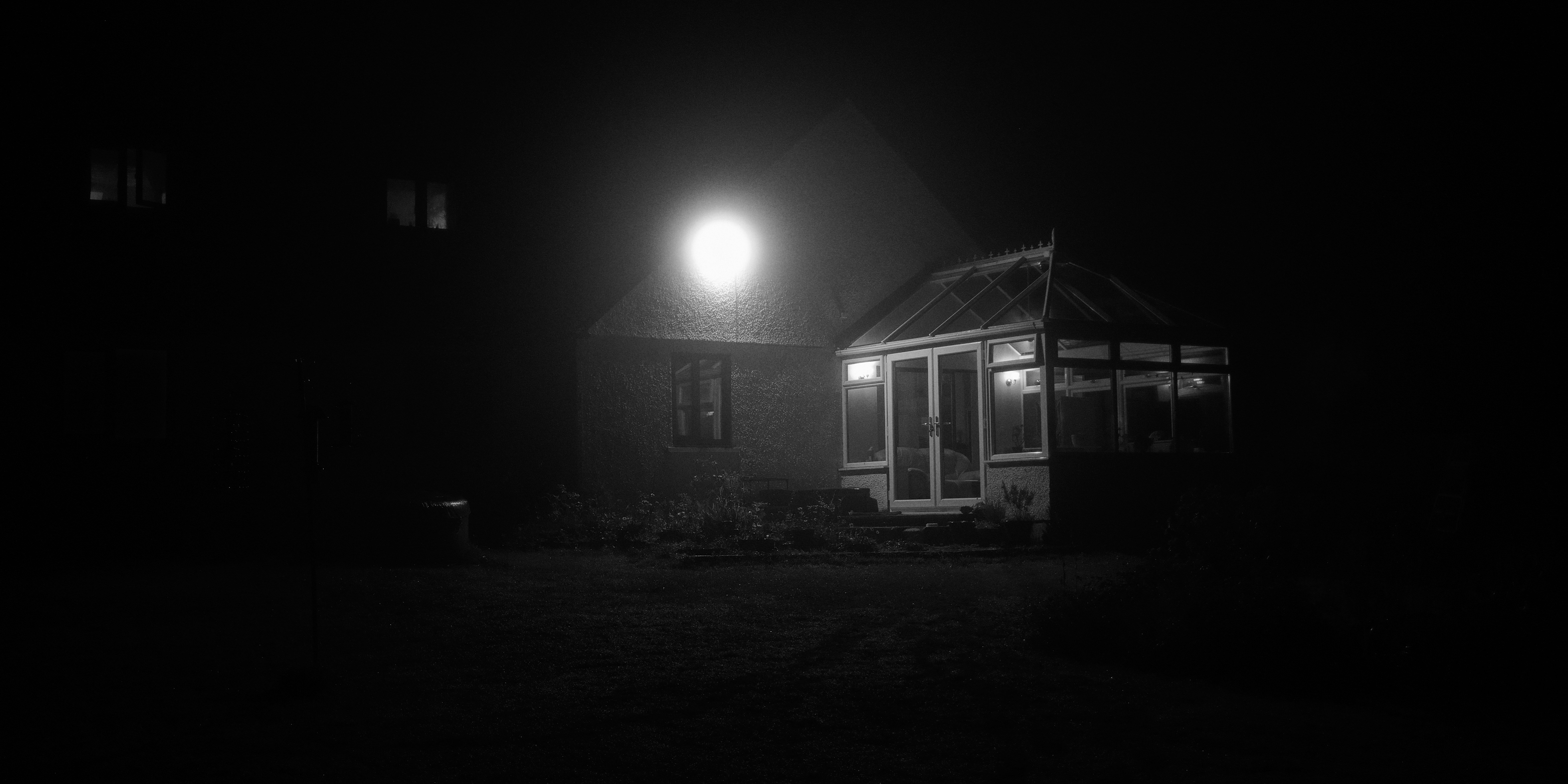 A black and white photo of a house at night