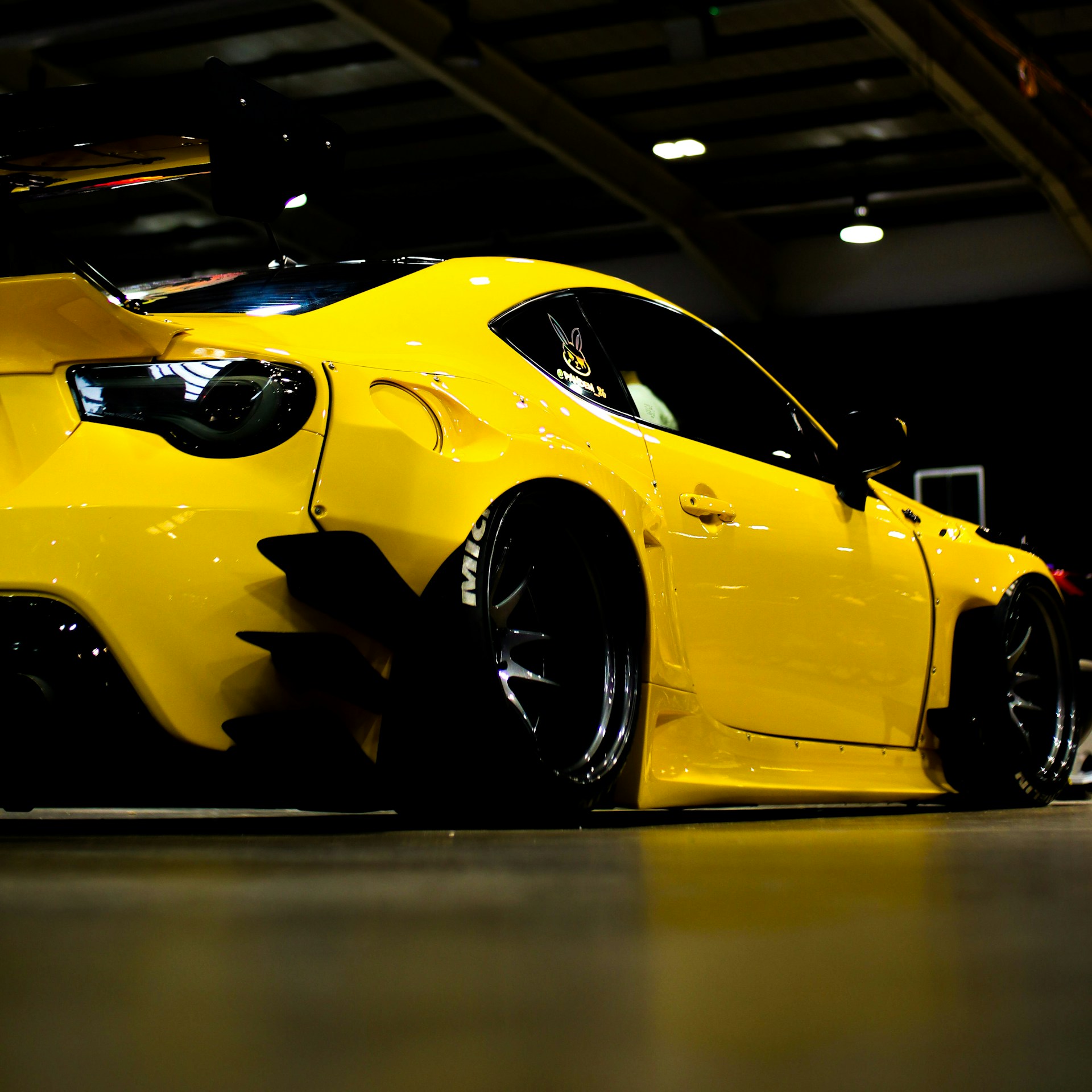 A yellow sports car parked in a garage