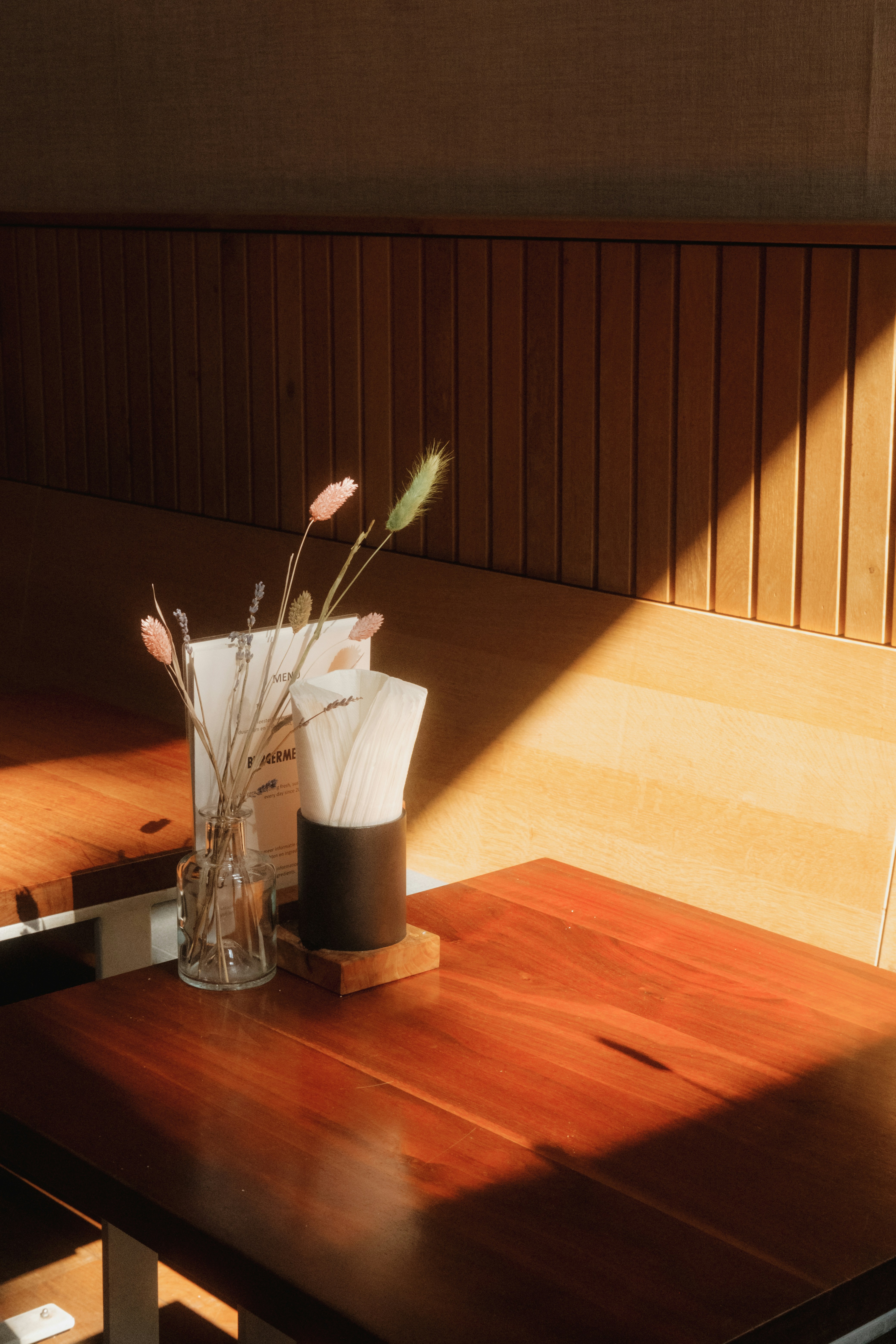 A wooden table with a vase of flowers on top of it