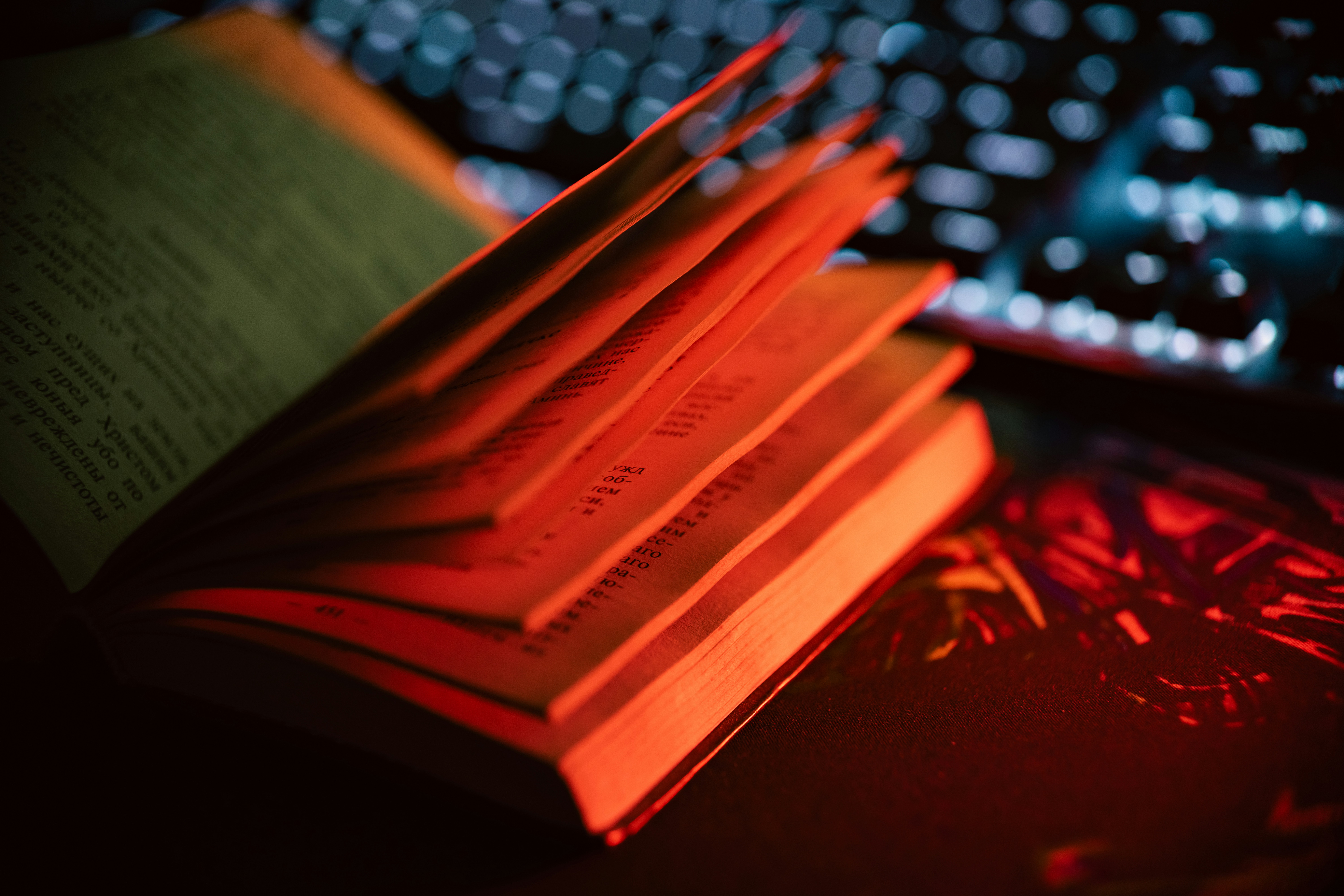 A book sitting next to a keyboard on a desk