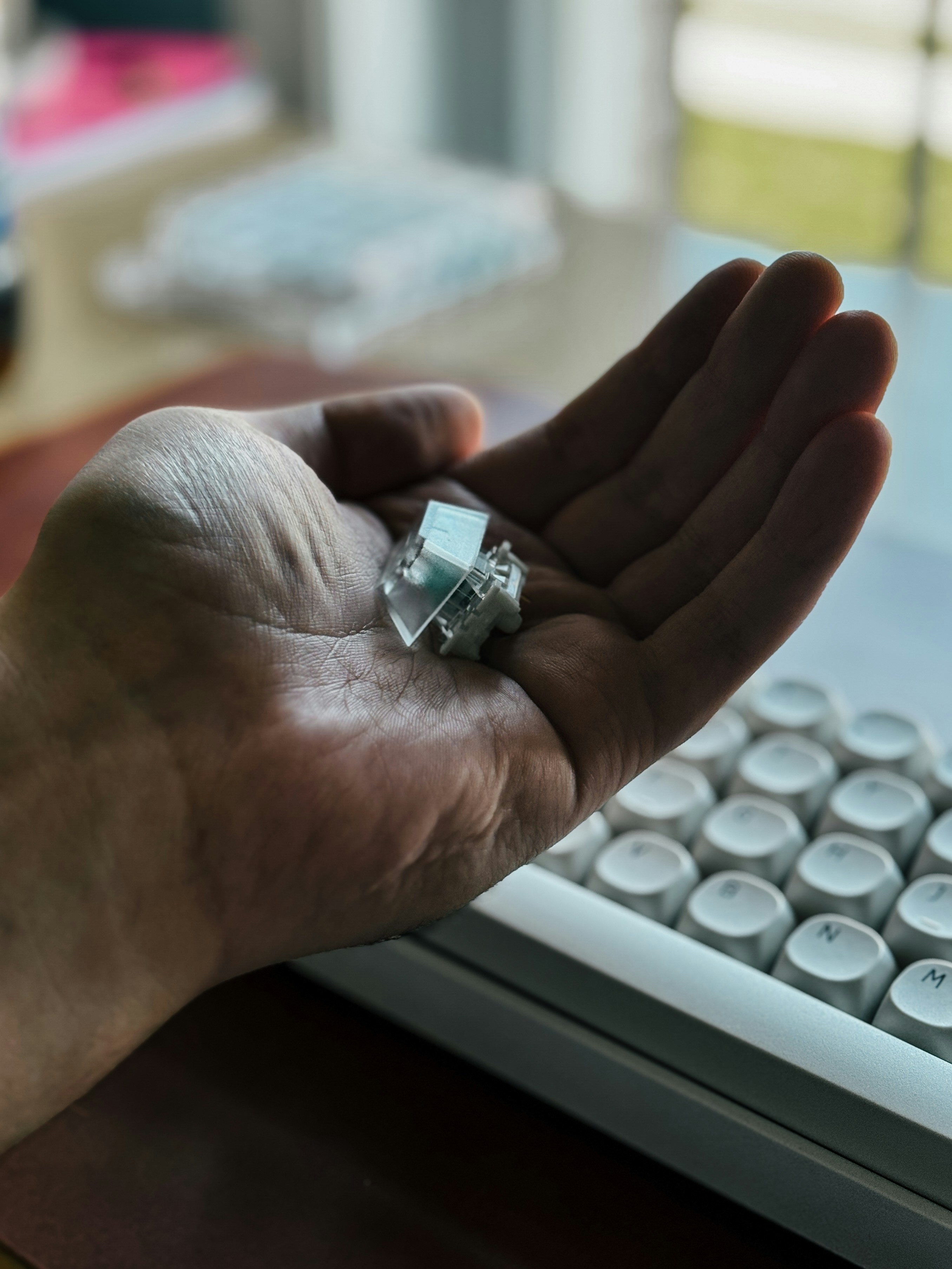 Une personne tient un anneau devant un clavier