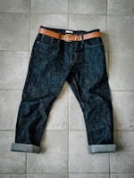 A pair of jeans laying on a tile floor