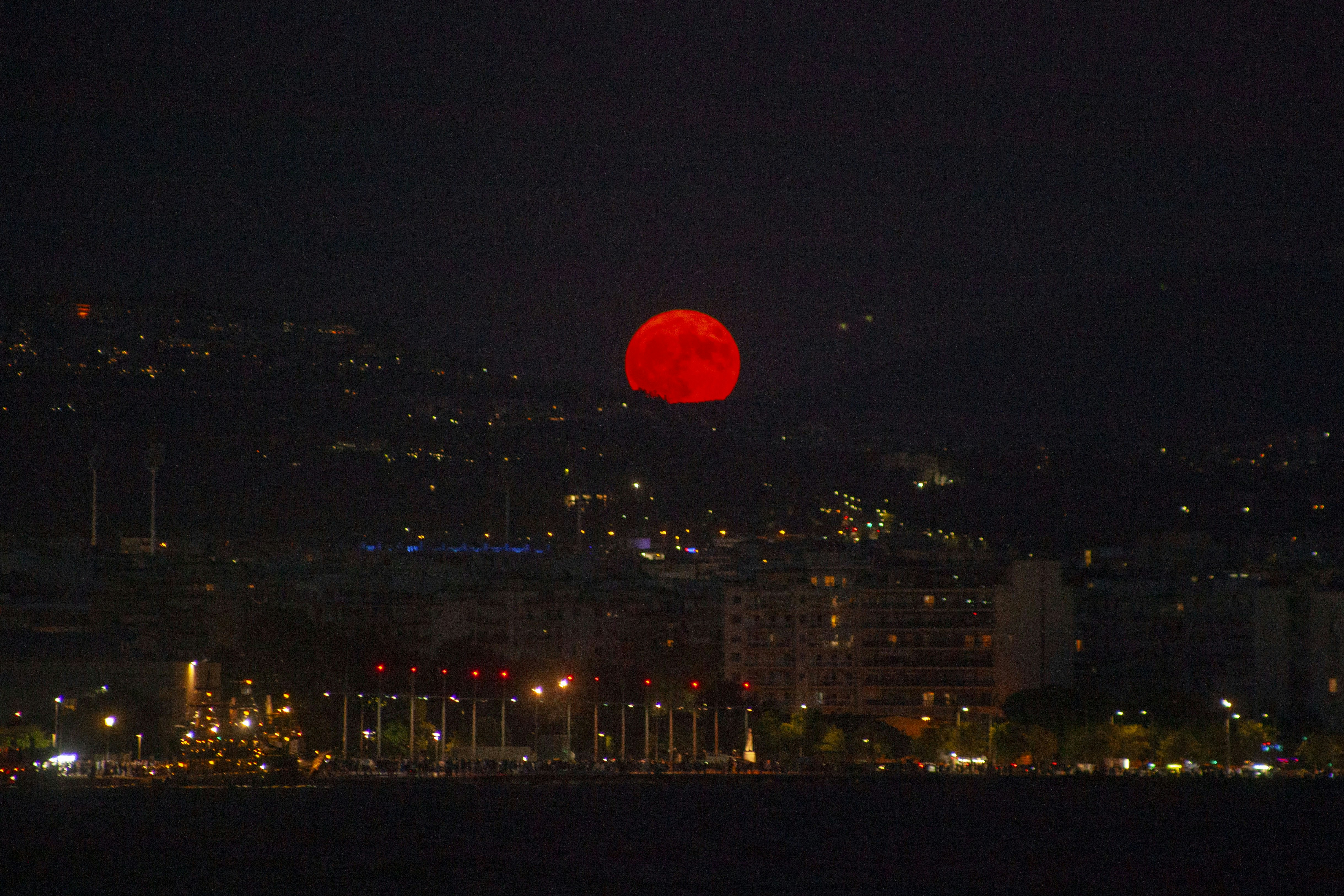 A red ball is in the sky over a city