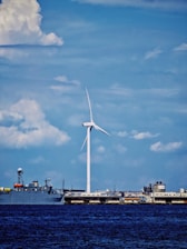 A large boat in the water near a wind farm