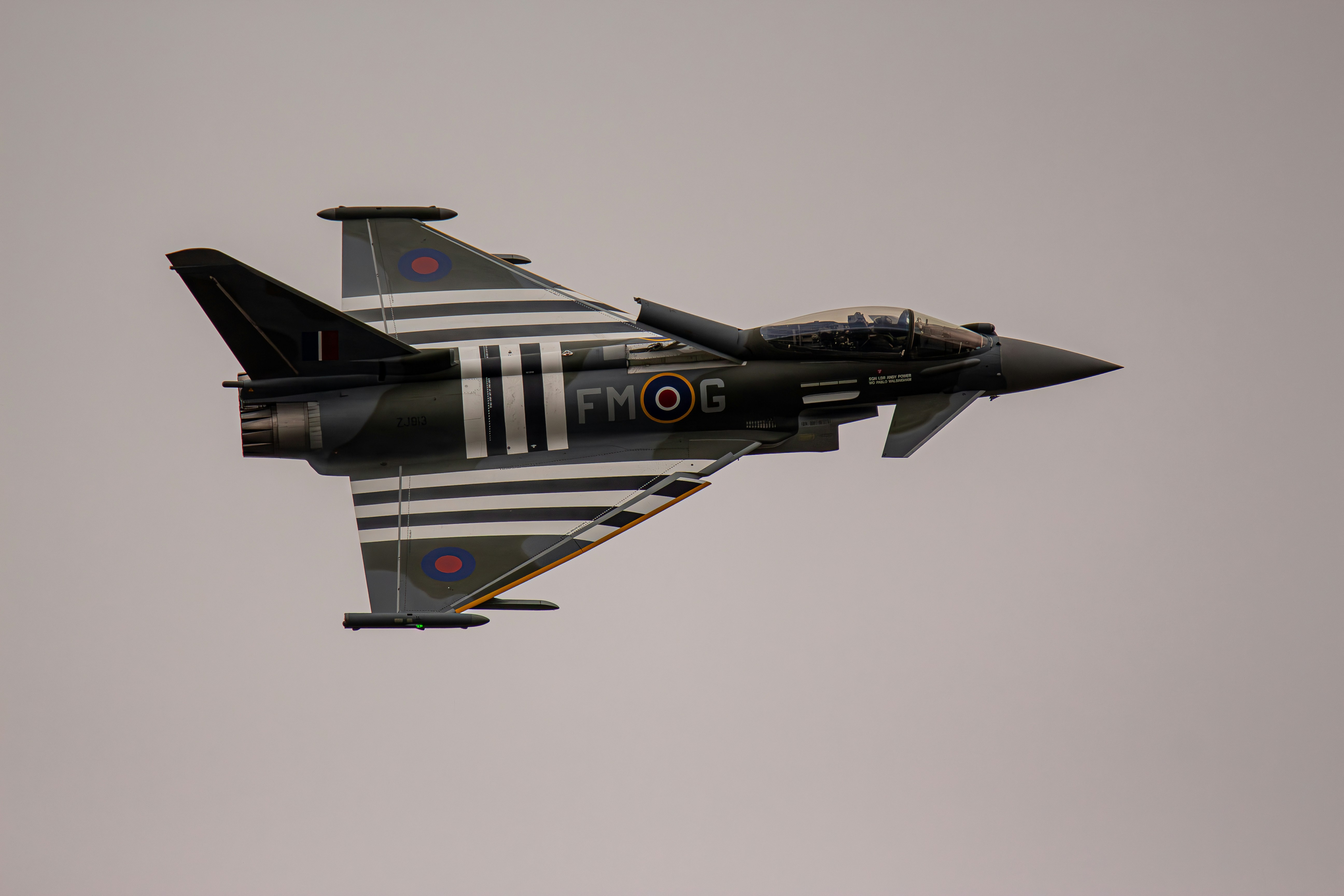 Ein Kampfjet, das durch einen grauen Himmel fliegt