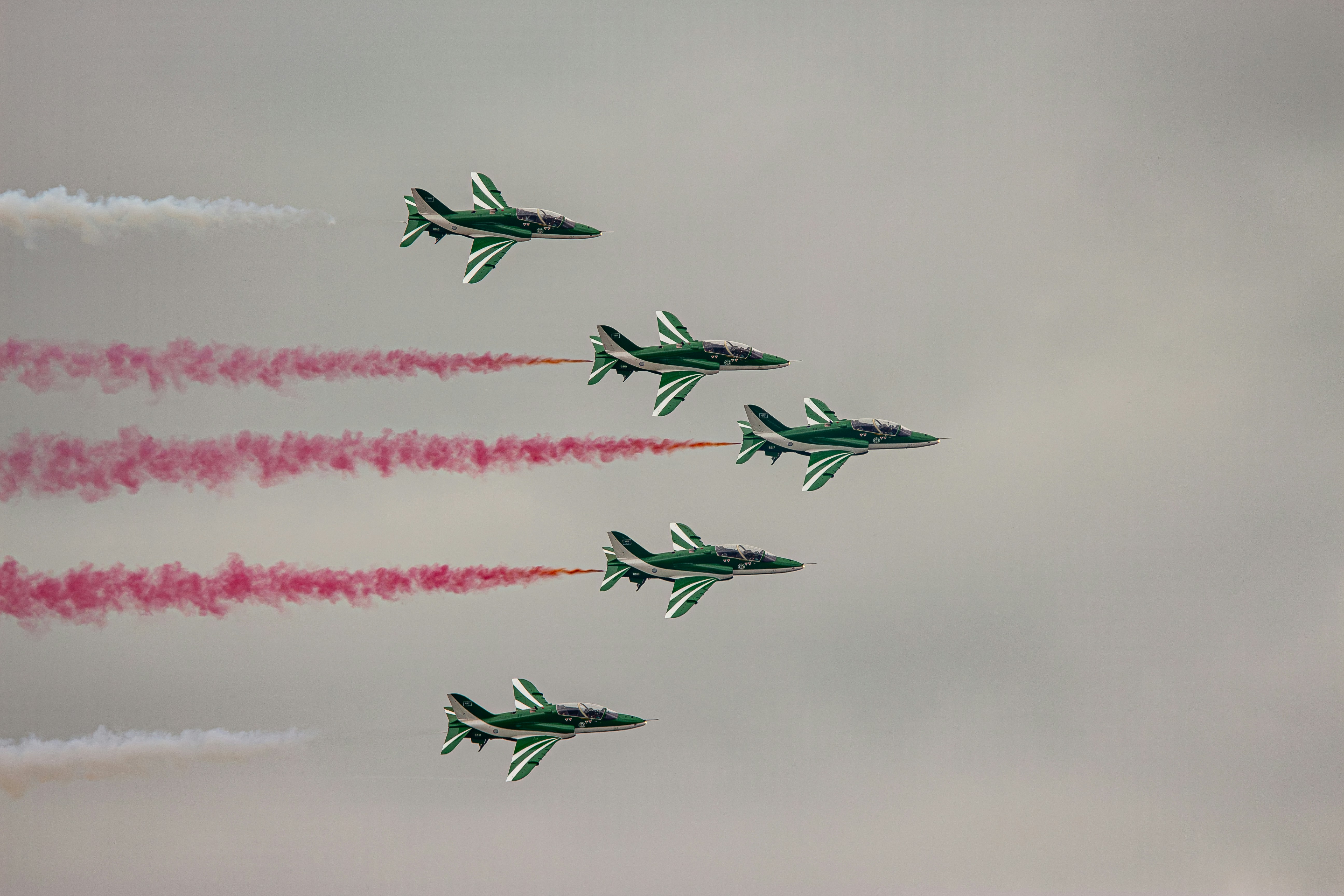 Eine Gruppe von Kampfjets fliegt durch einen bewölkten Himmel