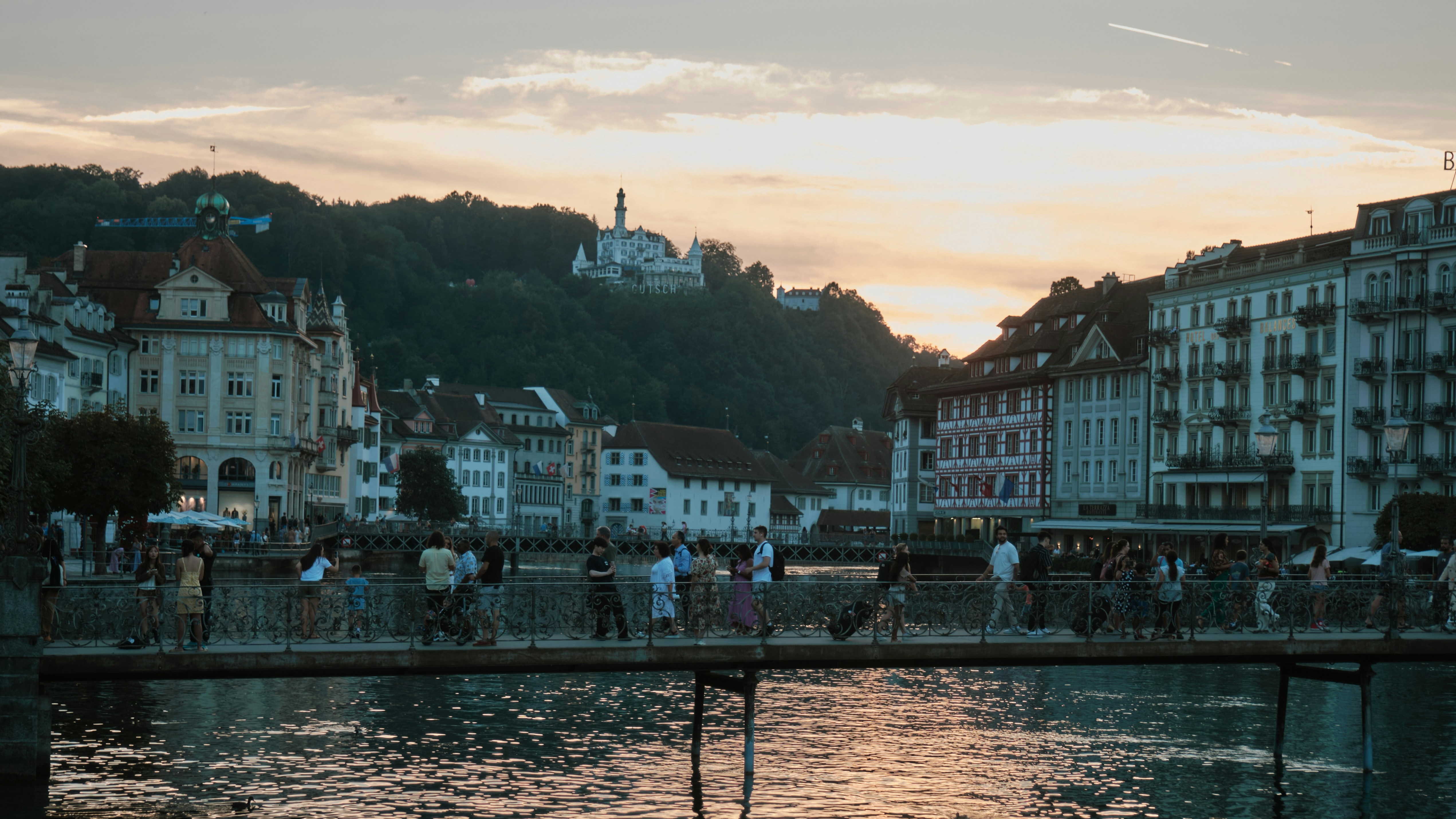 Des visiteurs traversant ensemble un pont au-dessus d une rivière tumultueuse lors d une excursion en Suisse