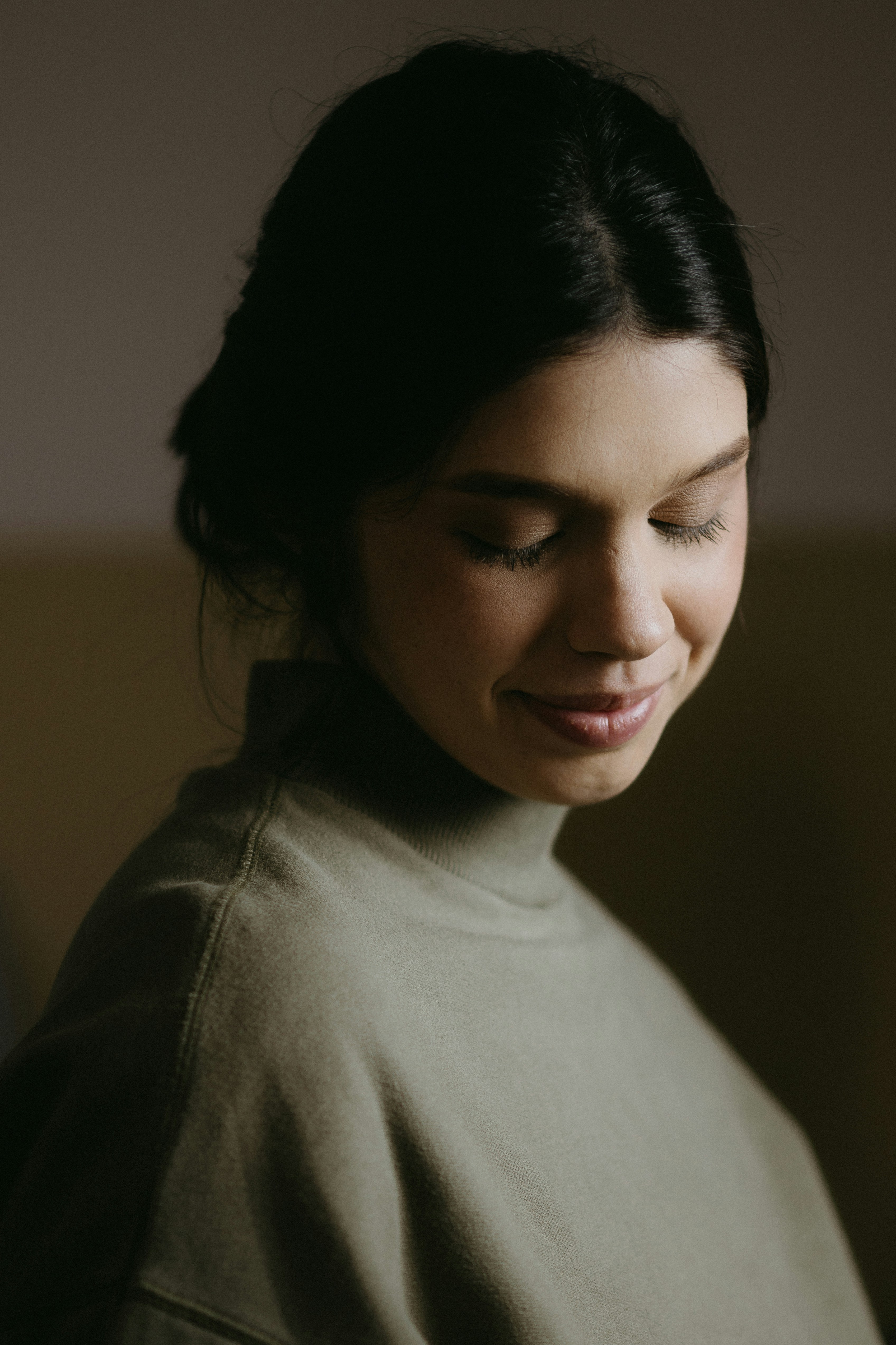 A woman is smiling and looking down at her cell phone