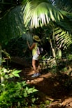 A woman walking through a lush green forest