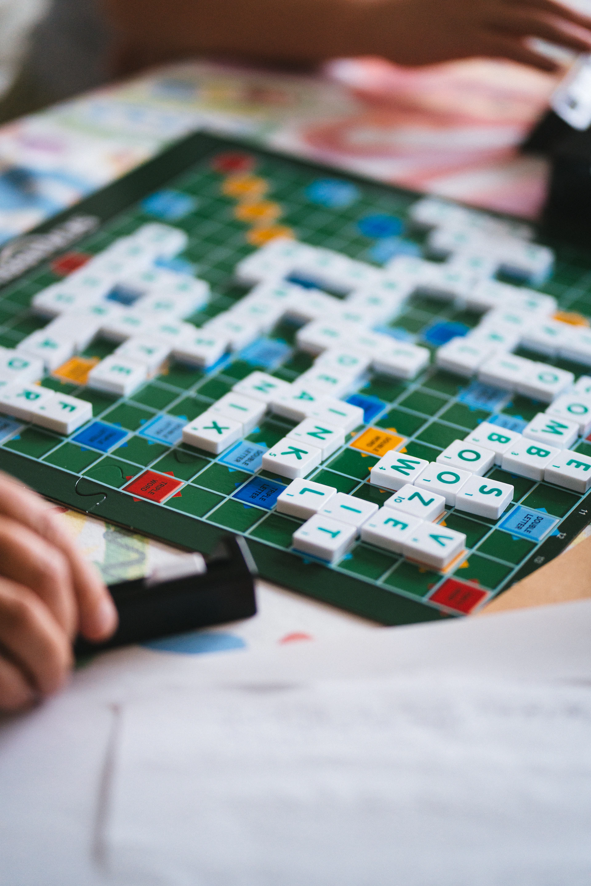 A close up of a person playing a game of scrabble