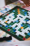 A close up of a person playing a game of scrabble
